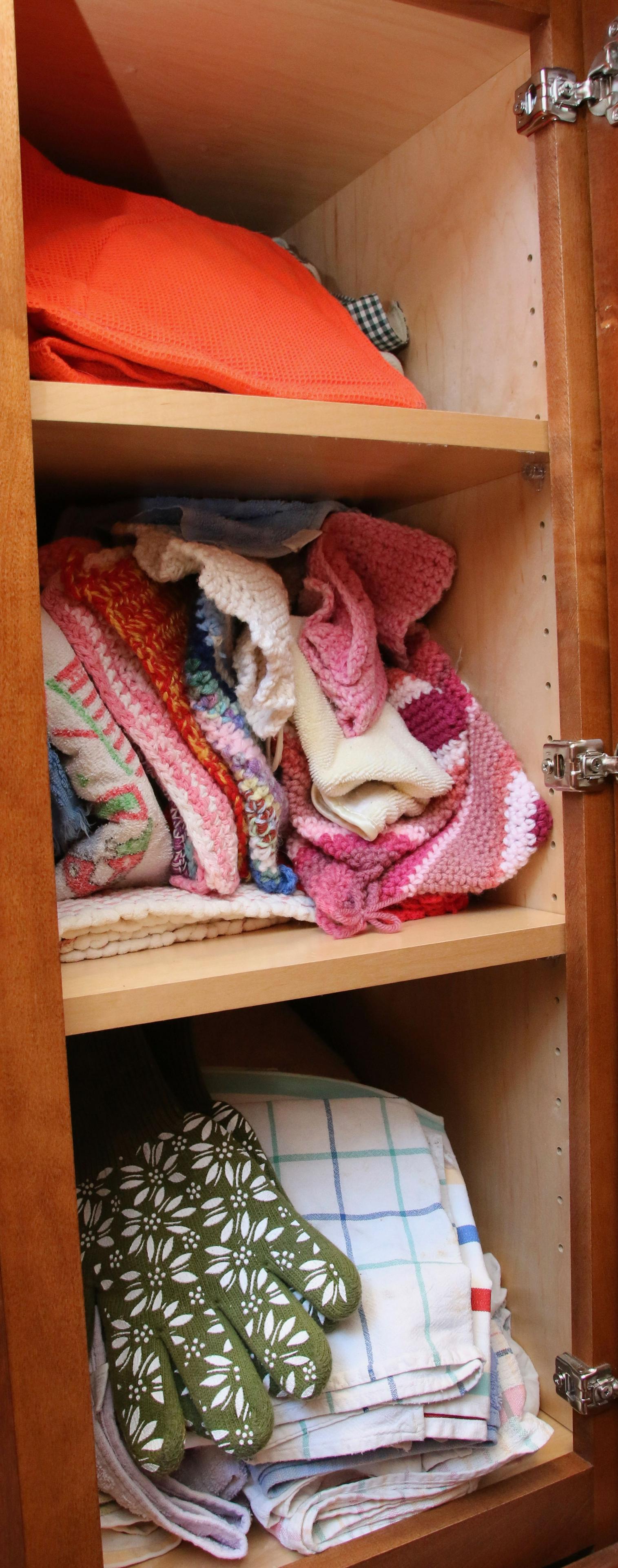 KITCHEN CABINET LOT: DRY GOODS - DISH TOWELS AND SOME TUPPERWARE