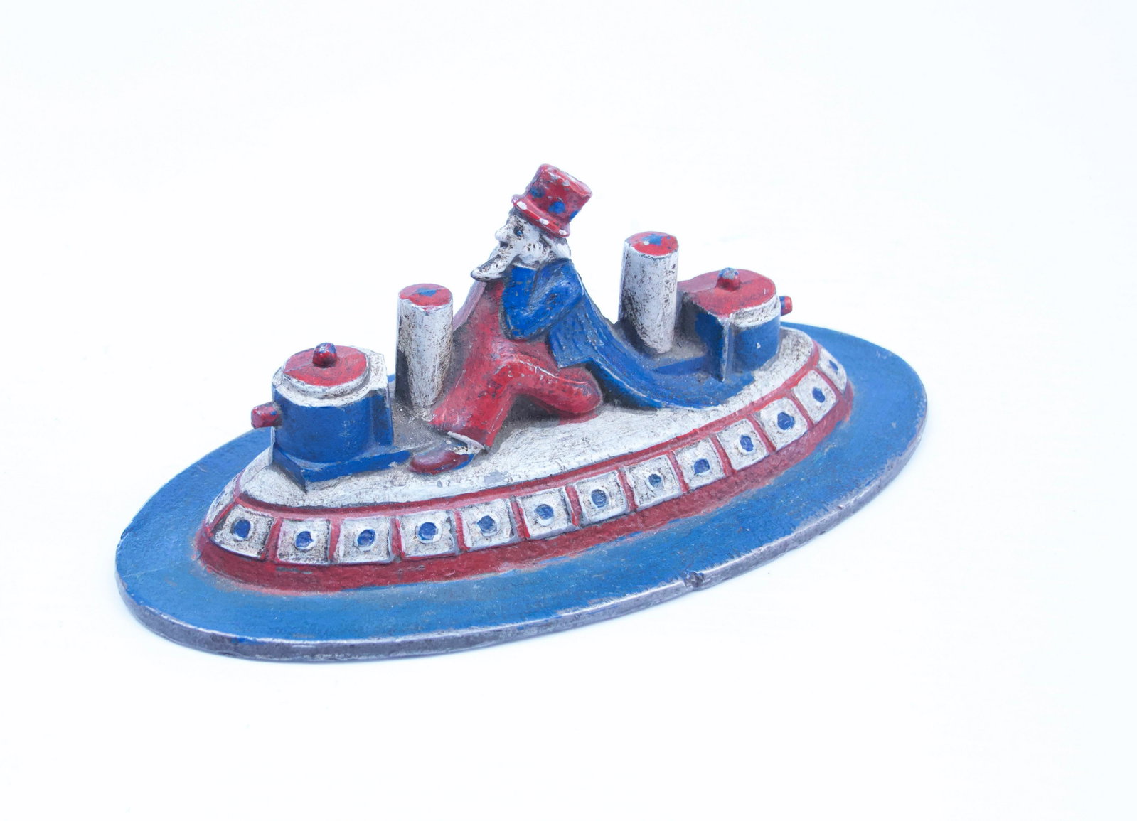CAST IRON PATRIOTIC DOOR STOP: UNCLE SAM RIDING BOAT OR SUBMARINE - IN ORIGINAL PAINT Dimensions: 7 3/4"