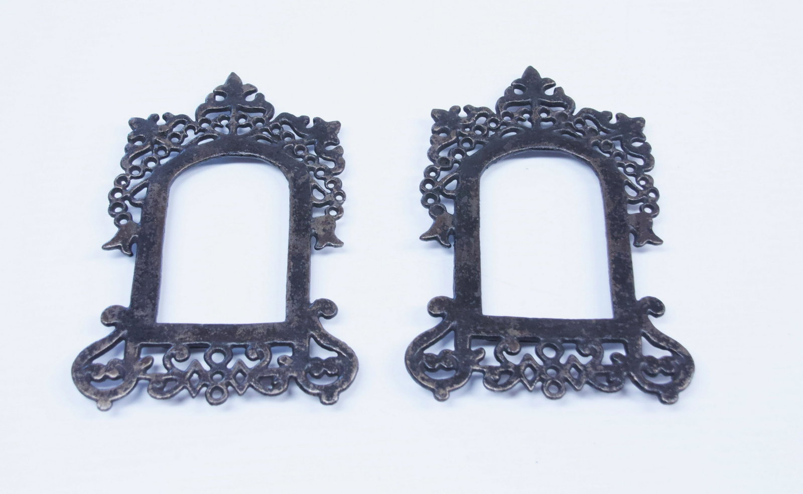 PAIR OF CAST IRON PICTURE FRAMES: FANCY DECORATION. PAINTED SURFACE Dimensions: 3 1/4" X 2 1/2" AND 7" X 4 1/4" TOTAL SIZE