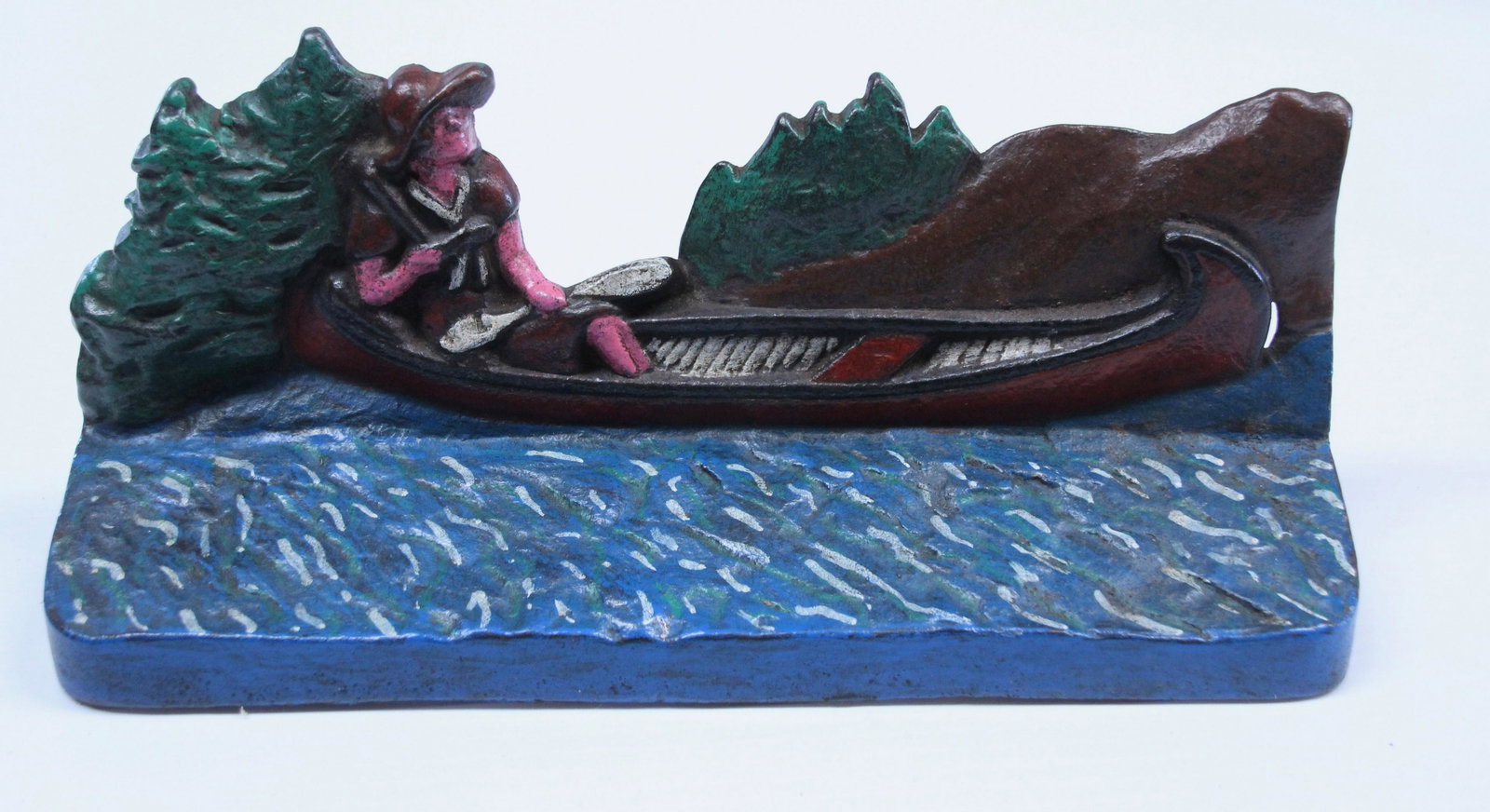 CAST IRON CANOE DOORSTOP: PAINTED CAST IRON GIRL IN CANOE. POSSIBLY REPAINTED Dimensions: 4 1/2" X 9 3/4"
