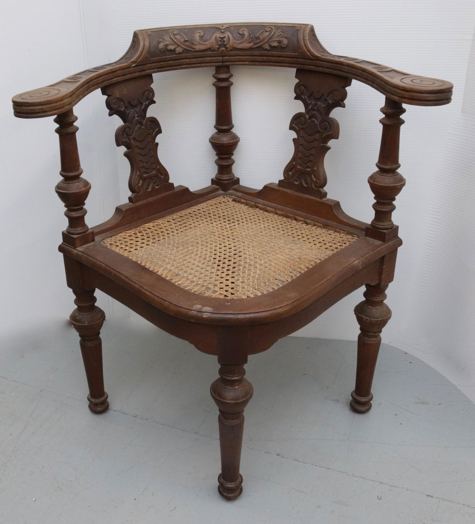 EARLY CARVED CORNER CHAIR: WALNUT CORNER CHAIR WITH CANE SEAT AND CARVED BACK 31" X 22"