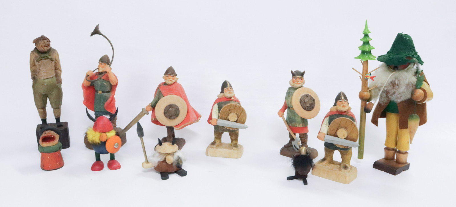 GROUP LOT OF CARVED WOODEN FIGURES: ELEVEN INCLUDING: (5) CARVED & PAINTED NORWEGIAN HENNING VIKINGS, (3) VIKINGS WITH FUR, CARVED MATCH HOLDER, CARVED FIGURE WITH TOOTHACHE AND WOODEN FIGURE WITH FELT CLOTHES 2" TO 8 3/4"