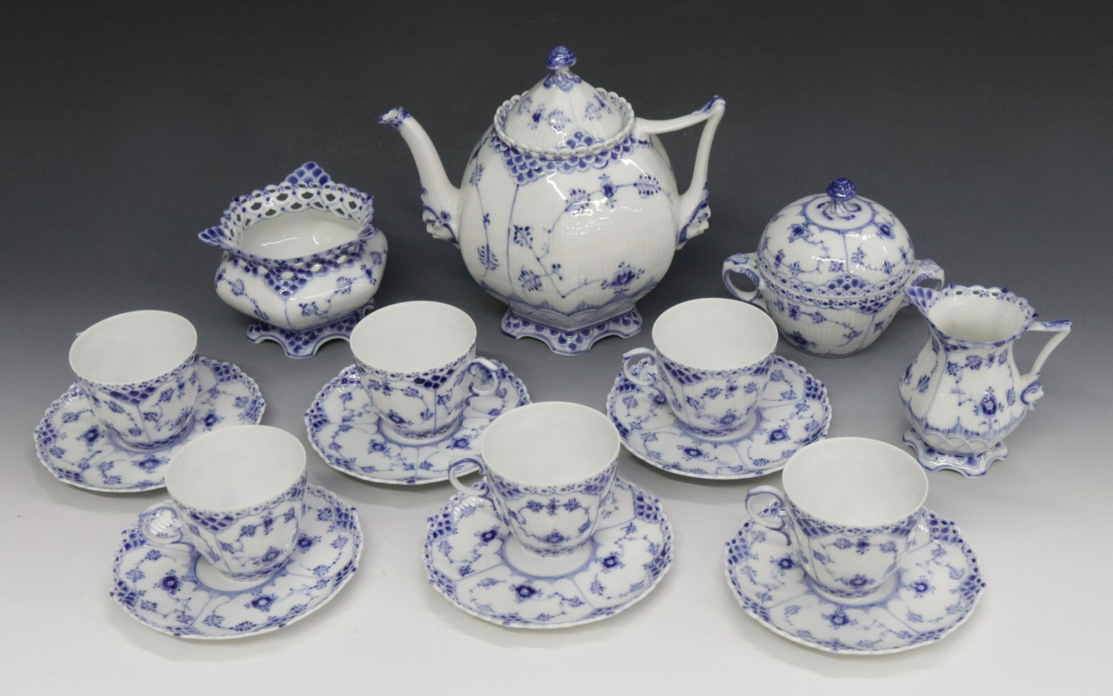 ROYAL COPENHAGEN DISH LOT: (6) TEA CUPS AND SAUCERS - TEA POT, SUGAR, CREAMER, AND WASTE POT Dimensions: TEA CUPS 2 1/2" X 5 1/2" - POT 8 1/4" X 8 1/2"