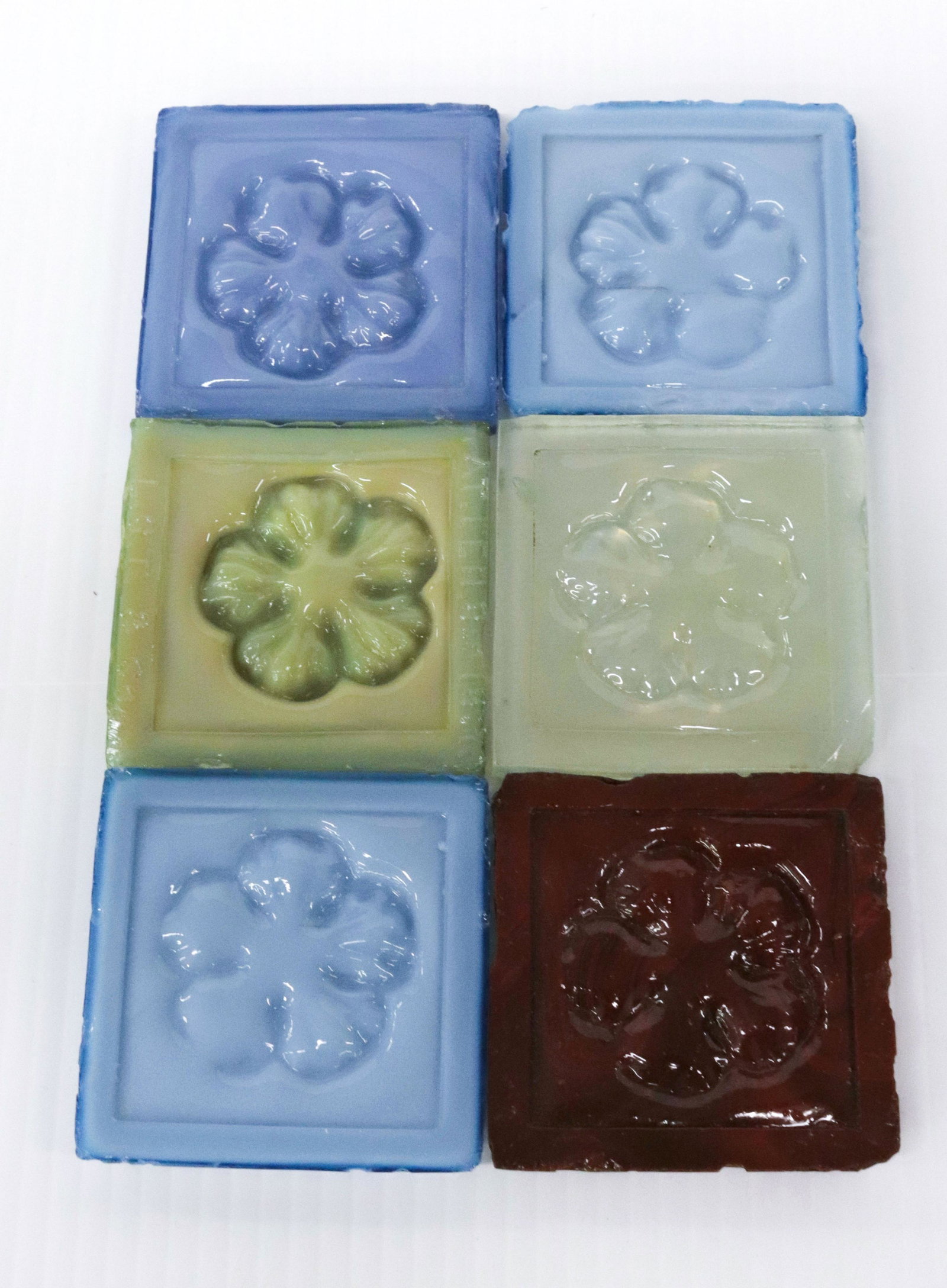 L.C. TIFFANY GLASS TILE LOT: (6) SQUARE TILES WITH ROSETTES - (2) BLUE, DARK BLUE, GREEN, TRANSLUCENT, AND RUST BROWN Dimensions: 3" X 3"