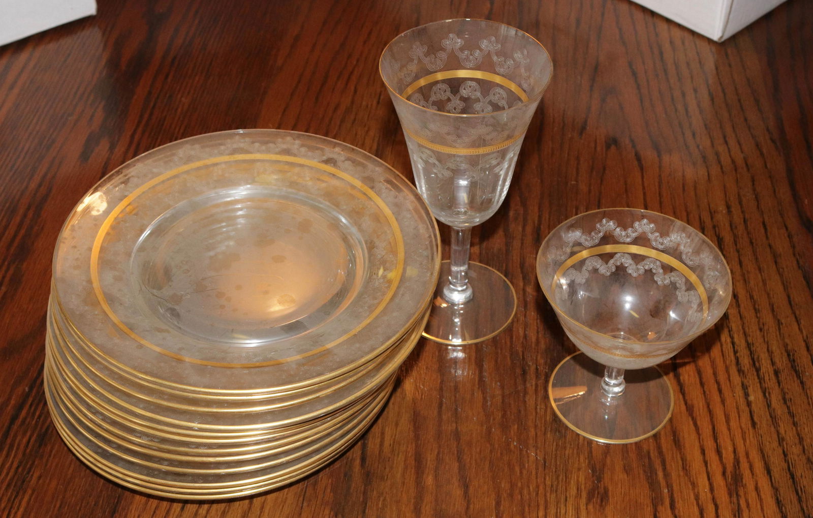 GLASS DISH SET: CLEAR GLASS DISH SET WITH GOLD GILT AND ETCHED DESIGN - (12) PLATES, (12) GOBLETS, AND (11) DESSERTS SIZE: PLATES 7 1/2" D
