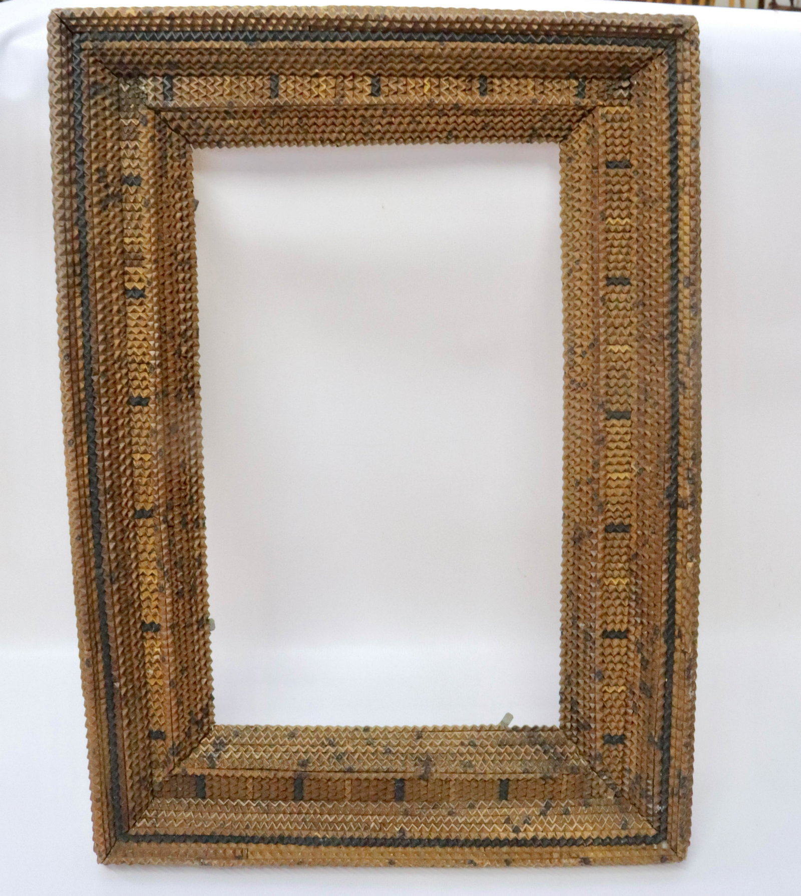 TRAMP ART FRAME: CHIP CARVED FRAME WITH DARK HIGHLIGHTS 23 1/4" X 17" TOTAL SIZE.