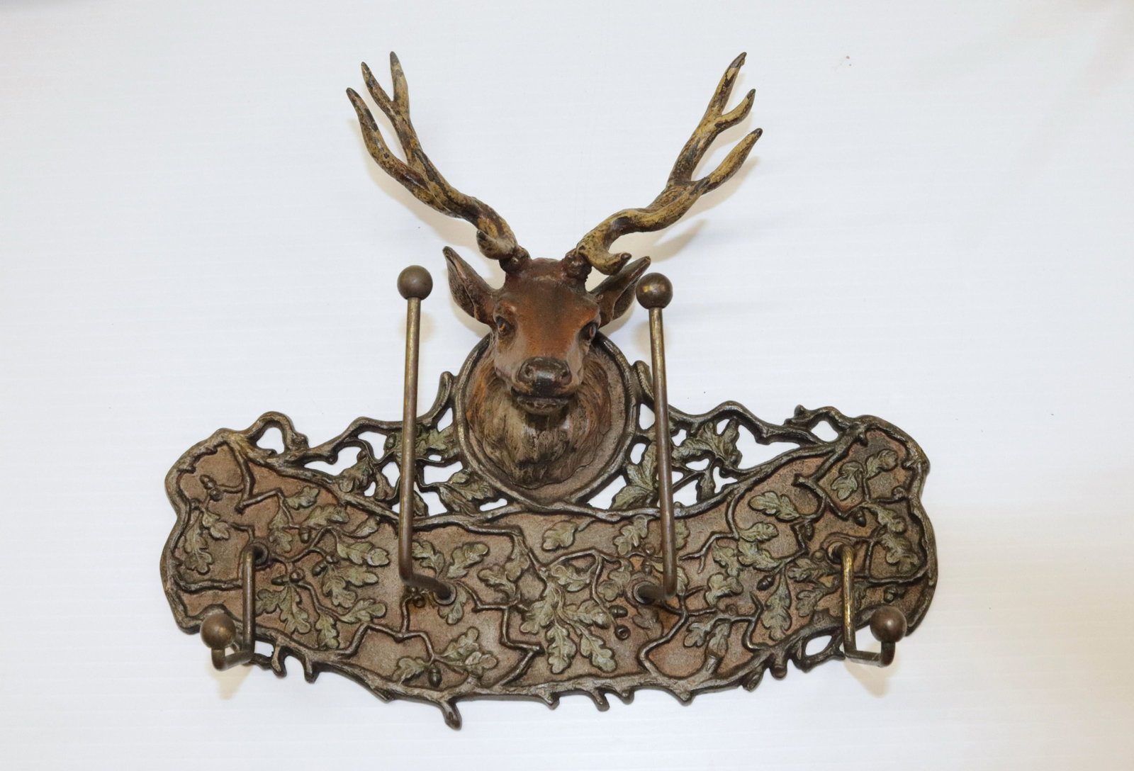 PAINTED CAST IRON AND METAL WALL HOOK: PAINTED BUCK WITH ANTLERS AND LEAF BACKGROUND. FOUR HOOKS 9" X 10"