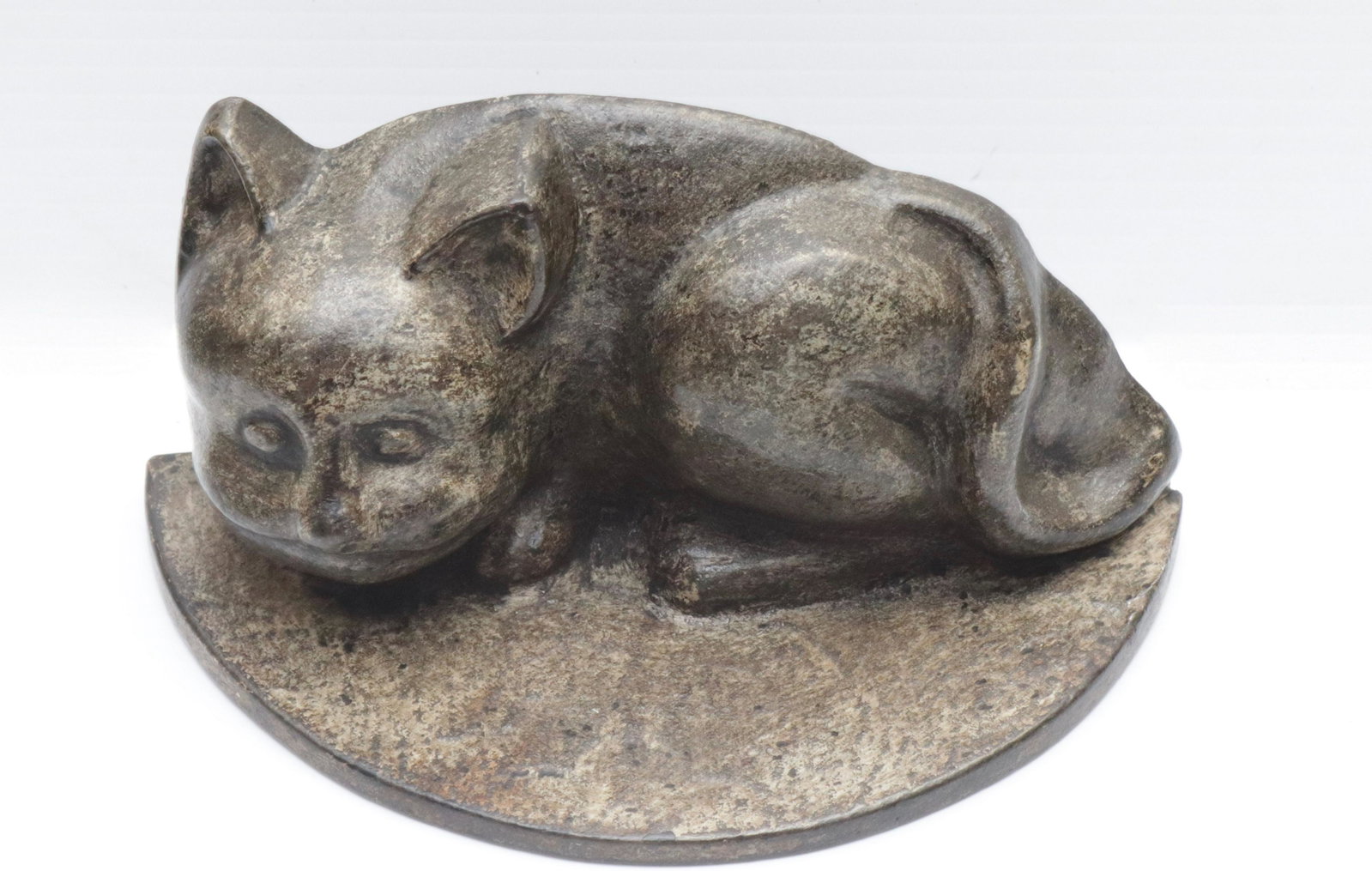 CAST IRON CAT DOORSTOP: PAINTED SURFACE. ON HALF MOON BASE 3.5" H X 7.5" L