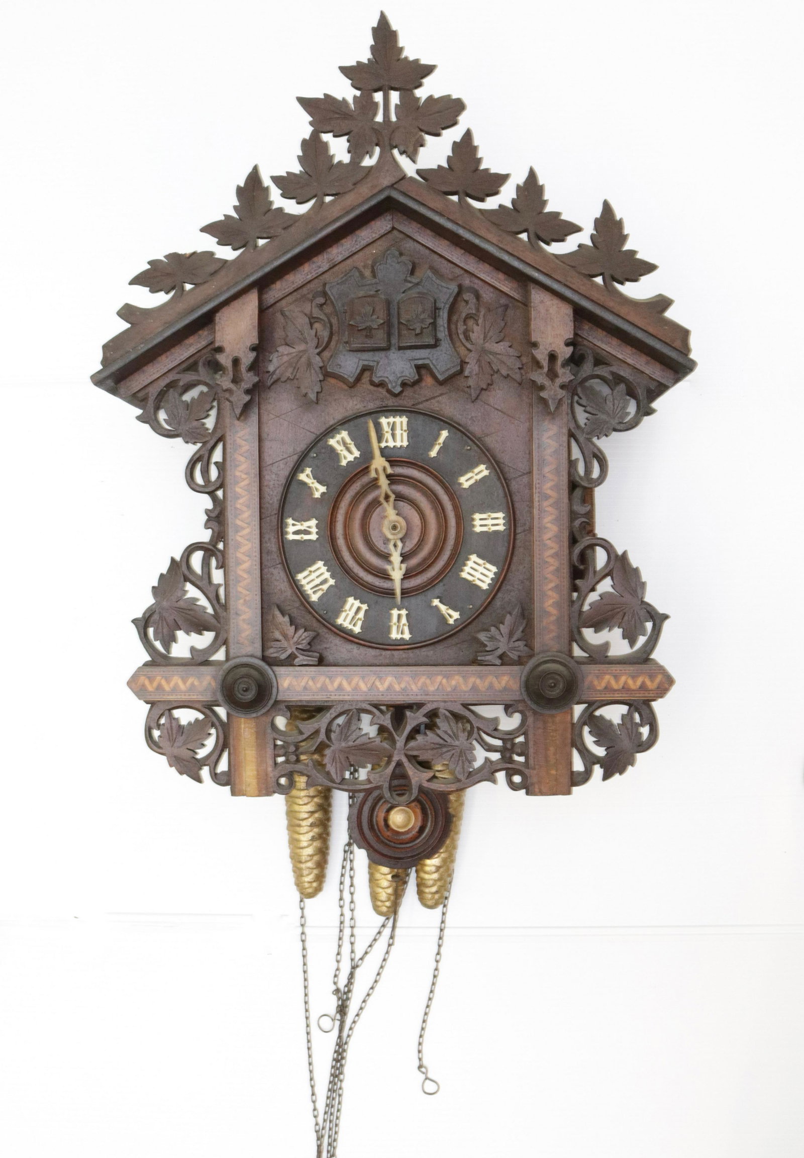 SWISS CLOCK CO. CUCKOO: CARVED AND INLAID CHALET STYLE. TWO CUCKOOS. PINECONE WEIGHTS. WOODEN PENDULUM 17" X 16.5"