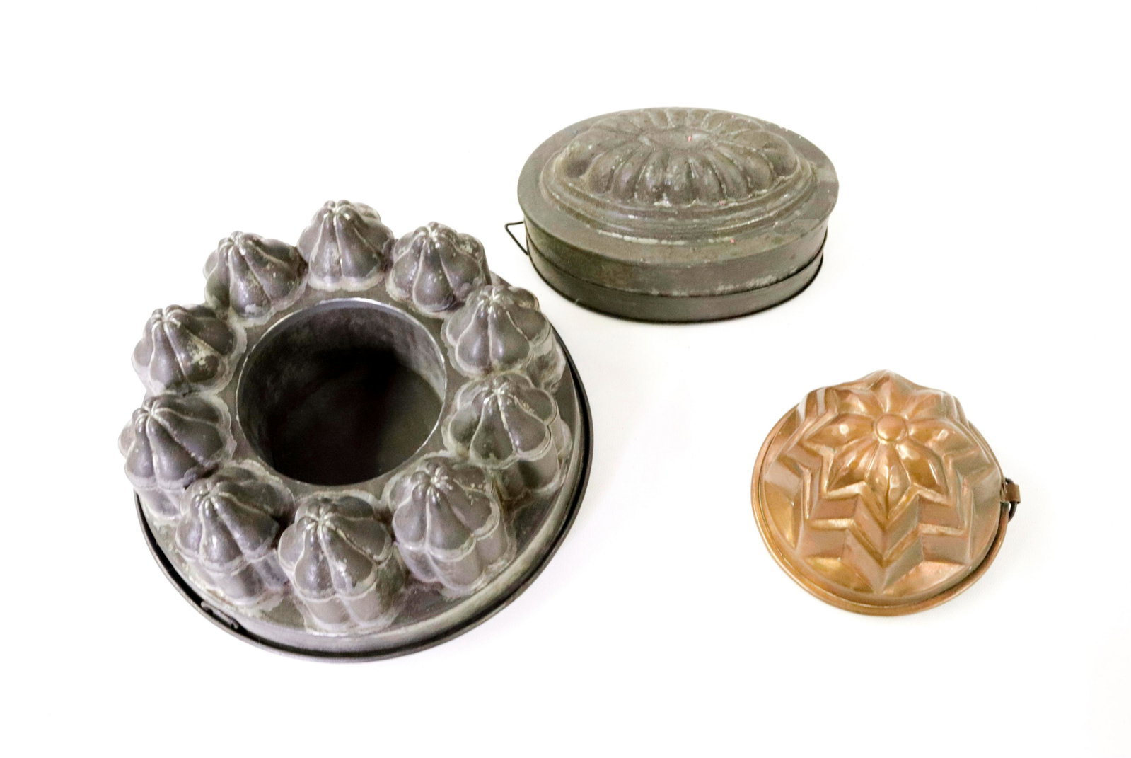 GROUP LOT OF FOOD MOLDS: (3) INCLUDING TWO TIN (LARGER MRKD. AUSTRIA, SMALLER ENGLAND) AND ONE COPPER Dimensions LARGEST 8.25" D