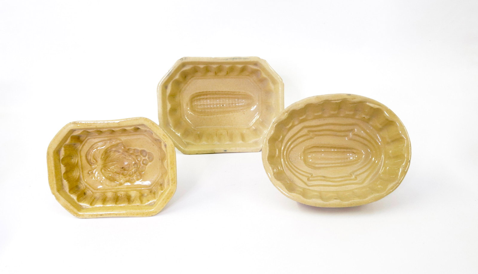 GROUP LOT OF YELLOW WARE FOOD MOLDS: (3) INCLUDING: GRAPES AND TWO CORN MOTIF Dimensions LARGEST IS 7.5" L