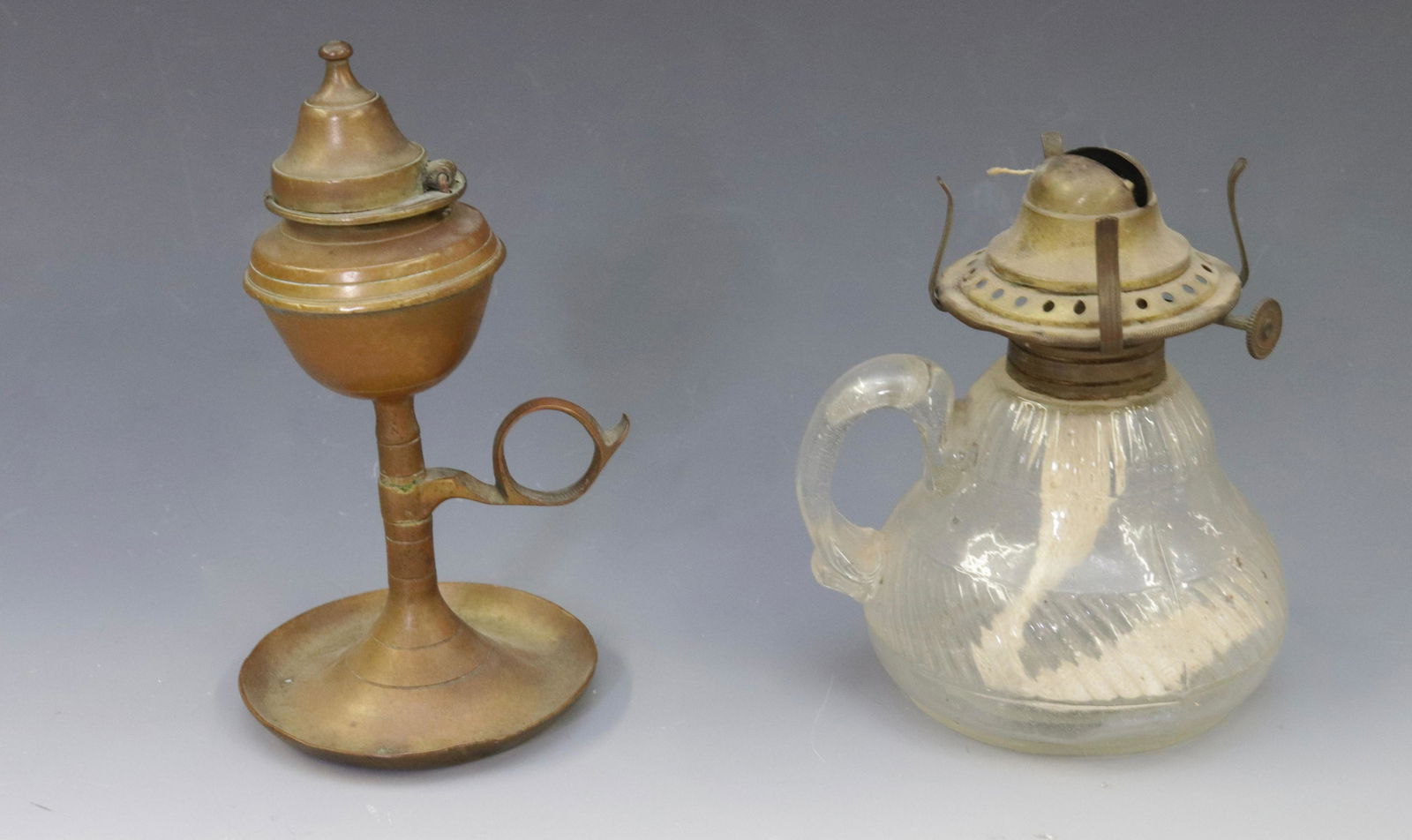 PAIR OF KEROSENE LIGHTS: ONE BRASS AND ONE GLASS WITH APPLIED FINGER RING Dimensions 3" TO 6.25" H