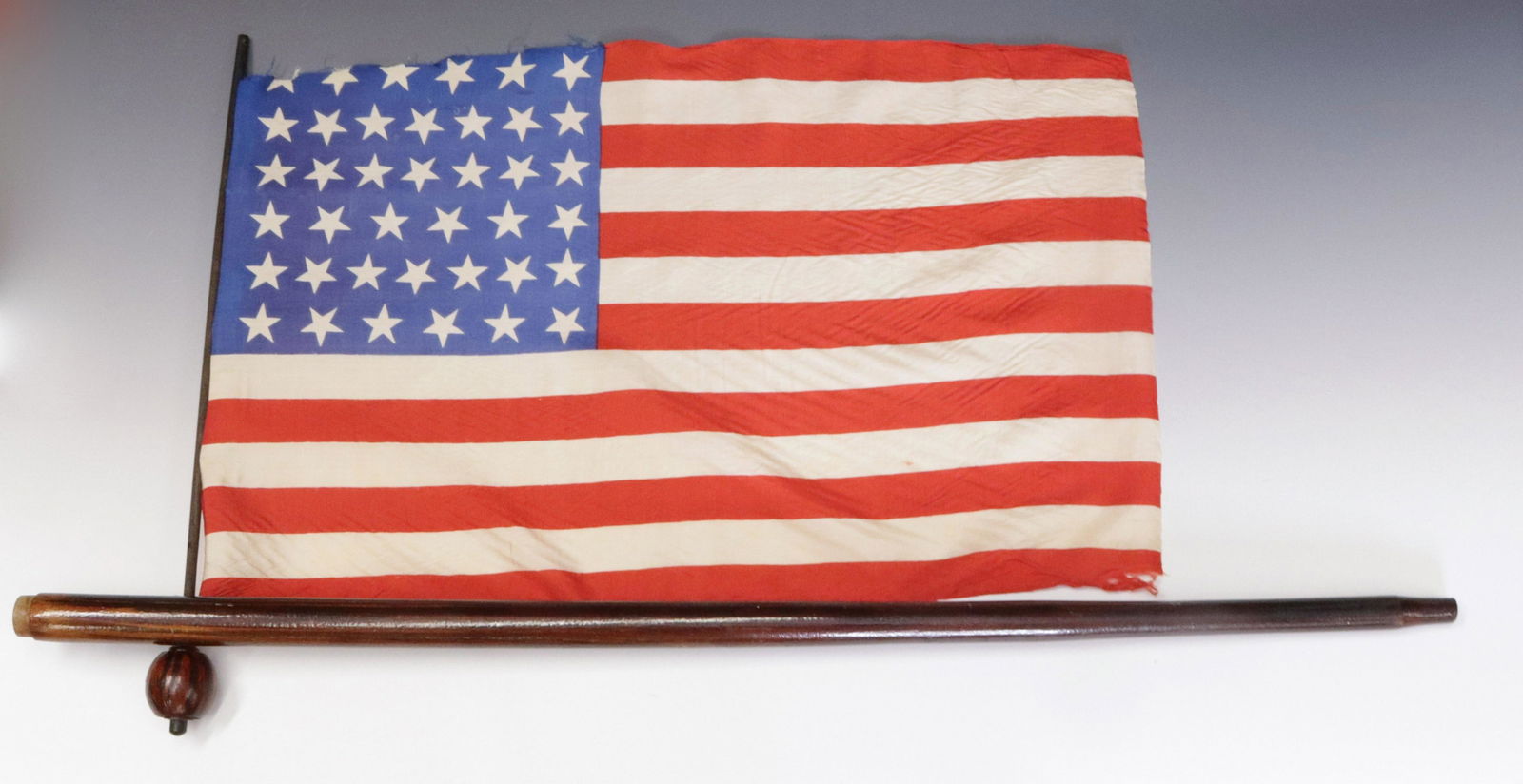 AMERICAN FLAG CANE: 39 STAR AMERICAN FLAG CANE - CONIFER WOOD CANE PAINTED LIGHT AND DARK BROWN TO SIMULATE ROSEWOOD - EBONY FITTING AT TOP - TOP PULLS OUT TO REVEAL 39 STAR SILK FLAG - TOP OF SHAFT EMBOSSED " PATENT APP