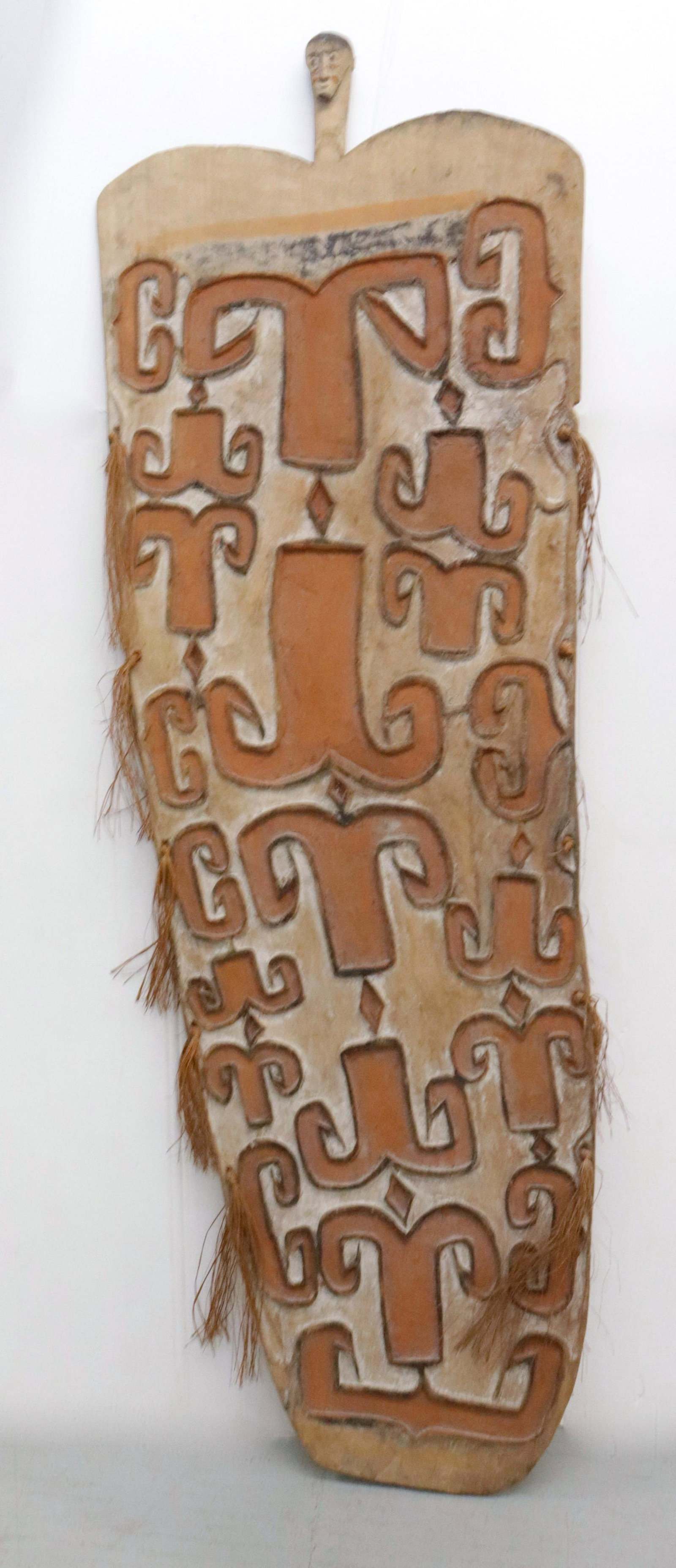 CARVED OCEANIC ASMAT WOODEN SHIELD: PAINTED AND CARVED SURFACE 66 1/2" X 22"