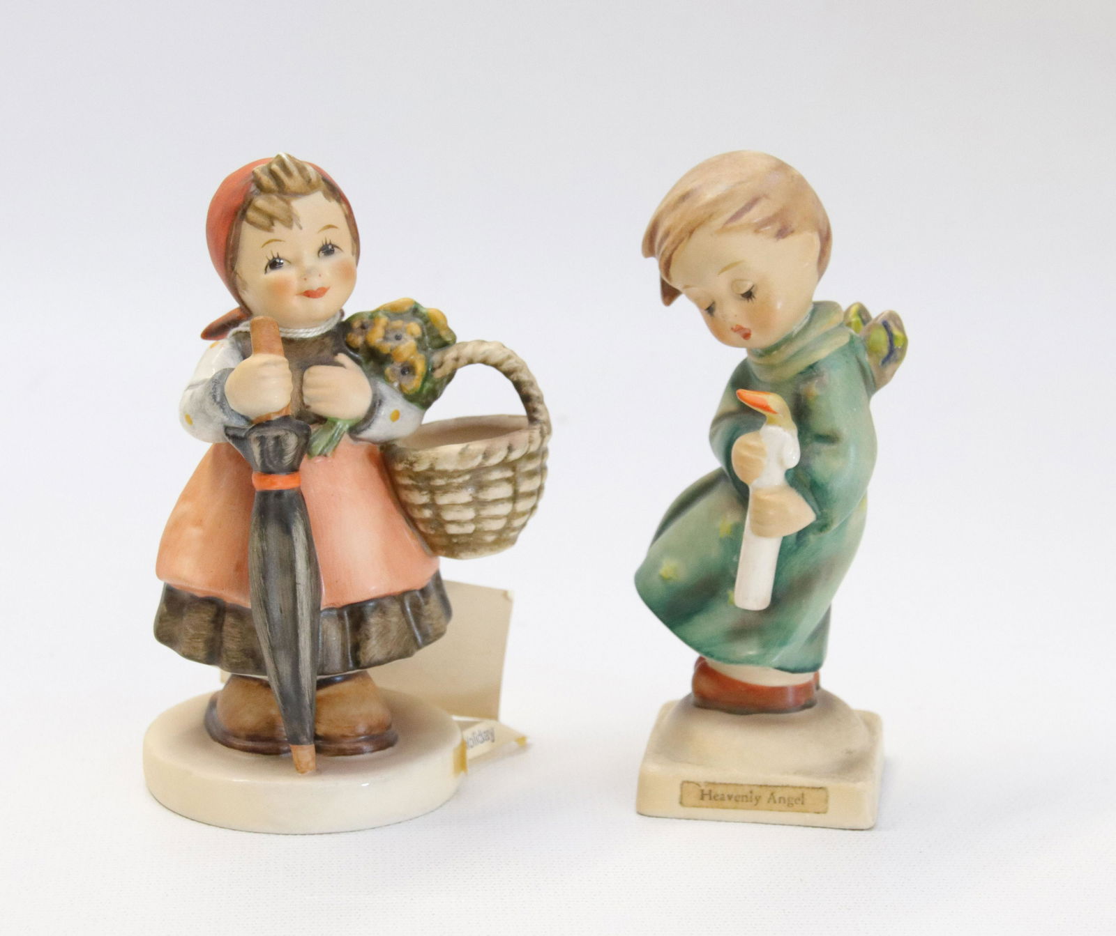 PAIR OF GOEBEL HUMMEL PORCELAIN FIGURES: HEAVENLY ANGEL #21, W. GERMANY AND ON HOLIDAY #350, W. GERMANY Size 4 1/4" H