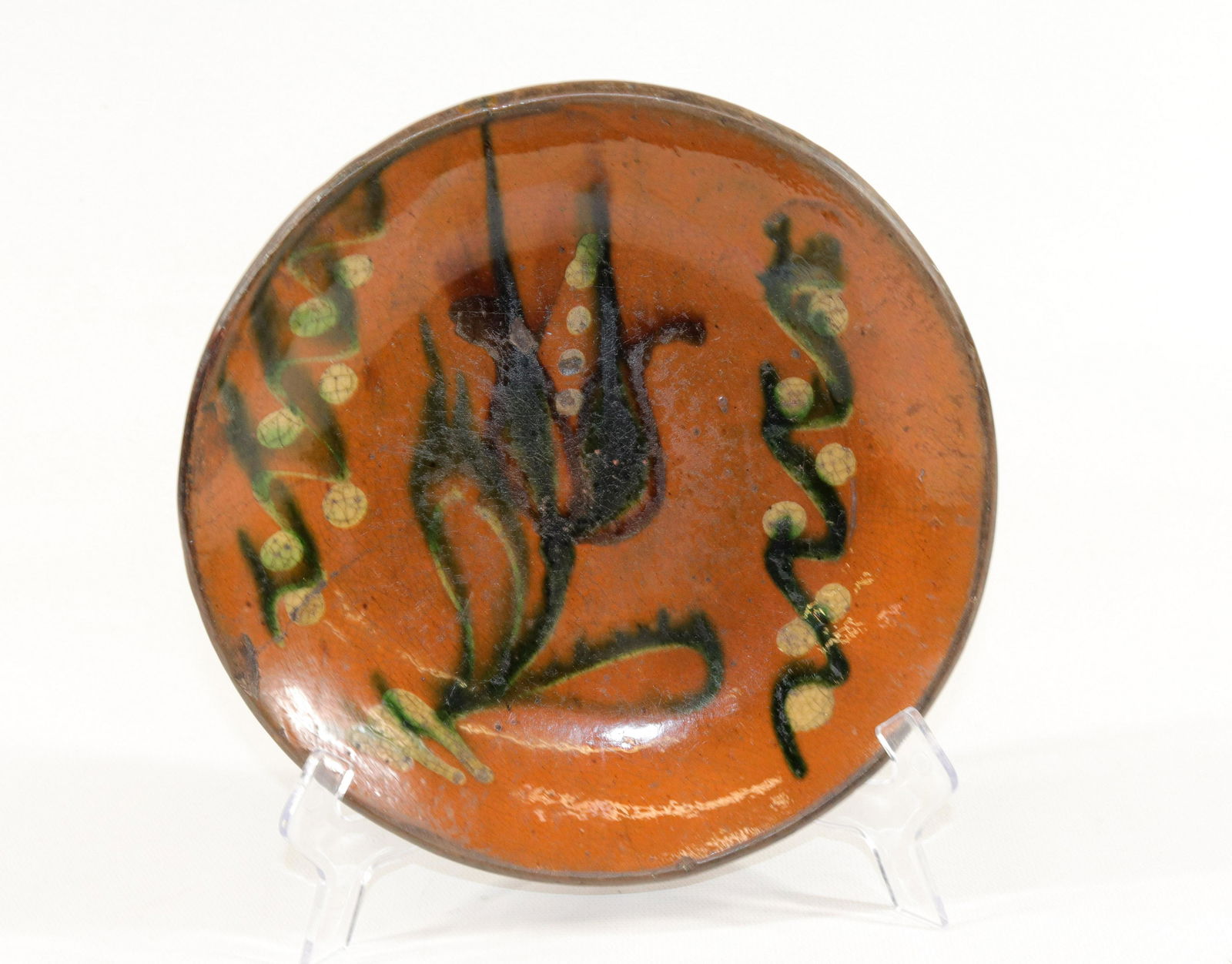 EARLY PENNSYLVANIA REDWARE PIE PLATE: TRI-COLOR SLIP GLAZED TULIP WITH WAVY LINES AND DOTS Size: 7 3/4" DIAMETER