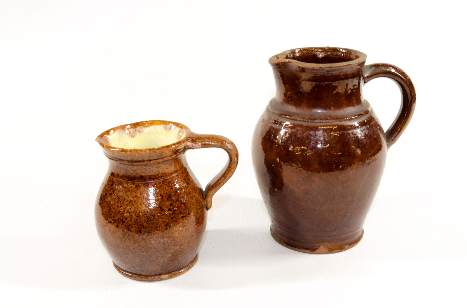 PR. OF REDWARE PITCHERS: (2) REDWARE PITCHERS - ONE WITH PALE YELLOW INTERIOR GLAZE Size: 5 1/4" X 7 1/2"