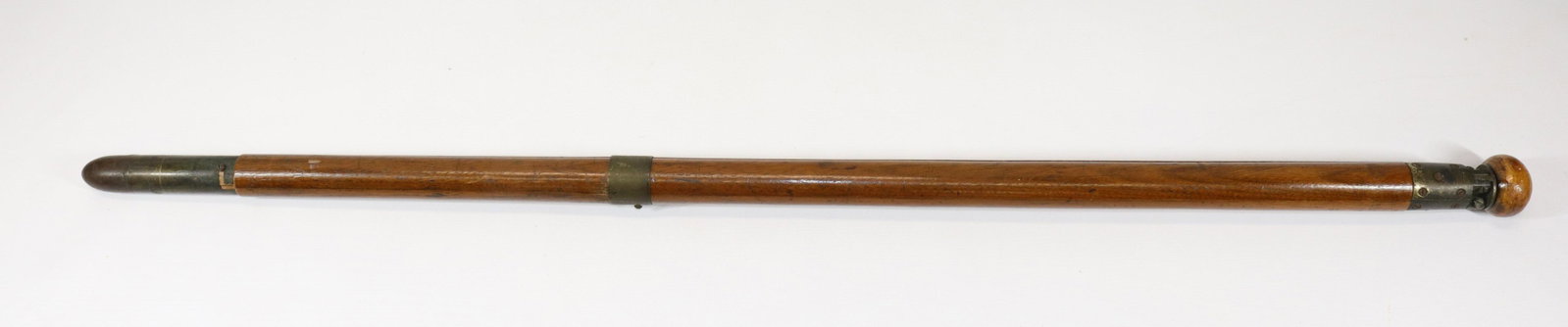 19TH CENTURY TRIPOD GADGET CANE: HEAVY WOODEN SHAFT WITH BRASS AND IRON. REMOVAL OF BRASS BAND CONVERTS CANE TO TRIPOD LEGS. POSSIBLY FOR A CAMERA ATTACHED AT TOP Size: 36" L