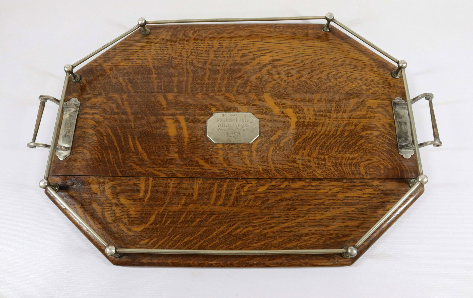 PHILADELPHIA ATHLETICS 1911 CHAMPIONSHIP TROPHY TRAY: AMERICAN LEAGUE CHAMPIONS. OCTAGONAL OAK WITH EPNS (ELECTROPLATED NICKEL SILVER). PAIR OF HANDLES ARE BASEBALL BAT SHAPED WITH EIGHT ENGRAVED BASEBALL TOPPERS (ONE MISSING). NAMES INCLUDE: EDDIE COLLI
