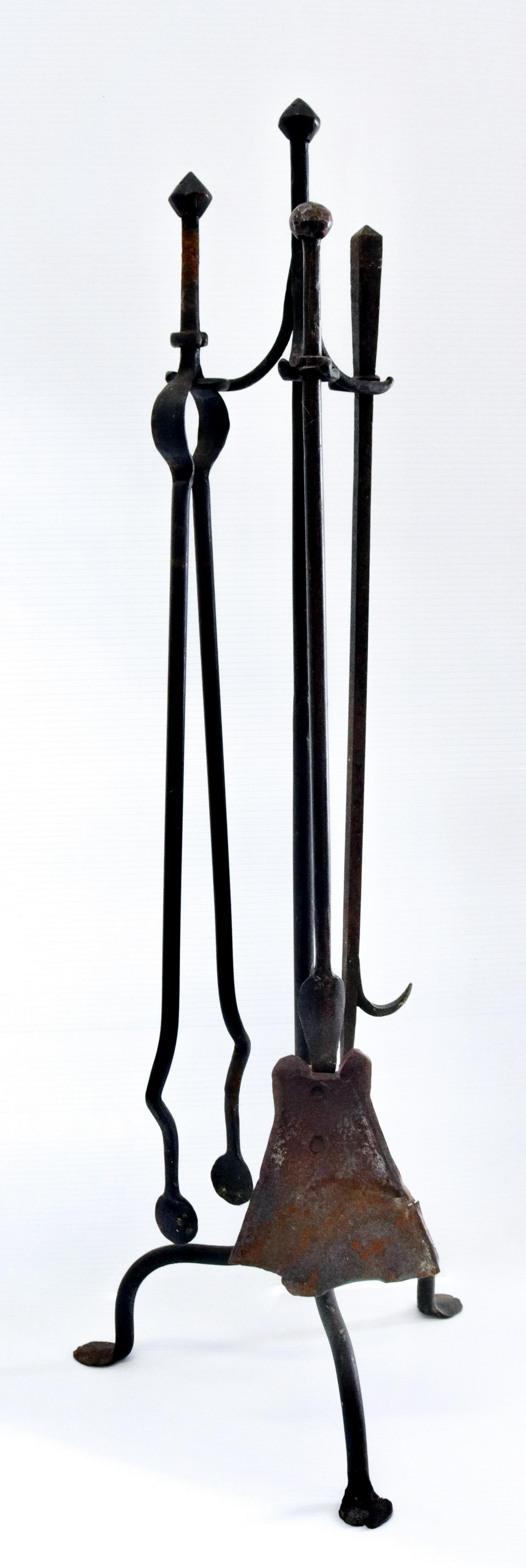 Wrought iron fireplace tool set: Description: Tongs, shovel, and poker - on tripod base stand Condtion: Loss to shovel - wear consistent with age and use Size: 39" H Consignor: JS Terms: This is an On-Site Online Only Auction. Pr
