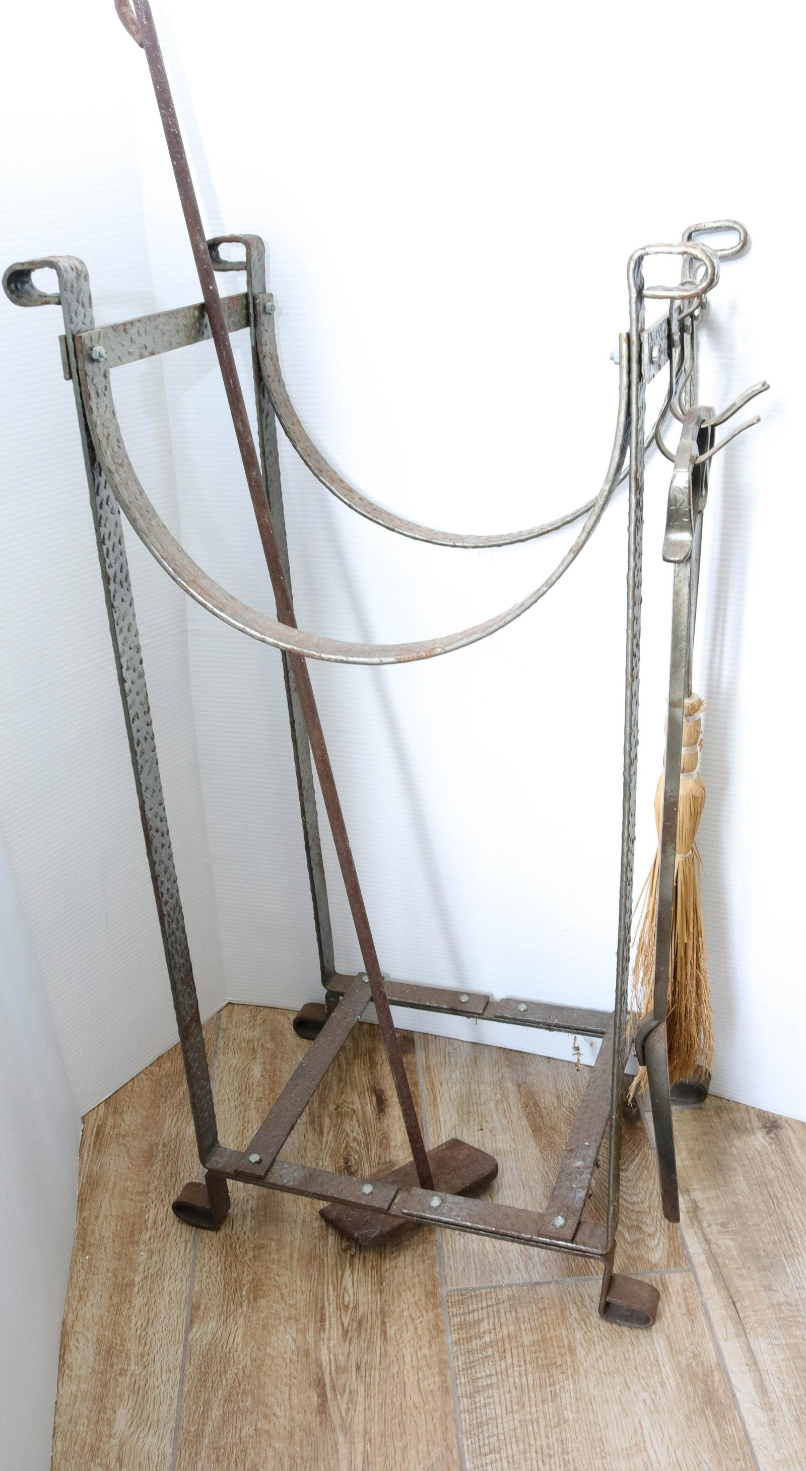 Vintage wrought iron log holder: Description: Hand hammered design with poker, brush, shovel, and scraper Condtion: Wear consistent with age and use Size: 34" X 18" X 13" Consignor: JS Terms: This is an On-Site Online Only Auctio