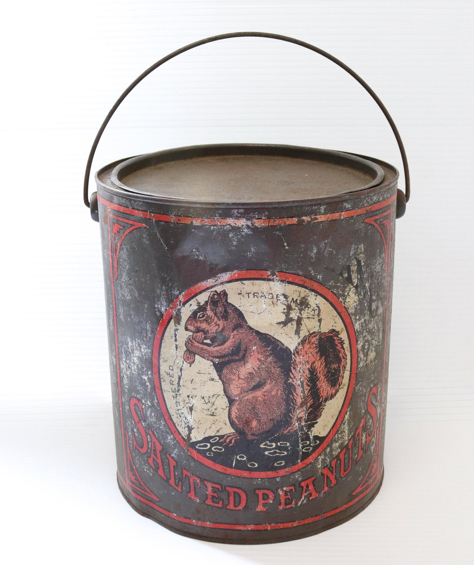 Advertising peanut tin: Description: Squirrel brand salted peanuts painted tin - double sided with bail handle Condtion: Some denting and wear to painted surface Size: 9" X 8 1/4" Consignor: JS Terms: This is an On-Site