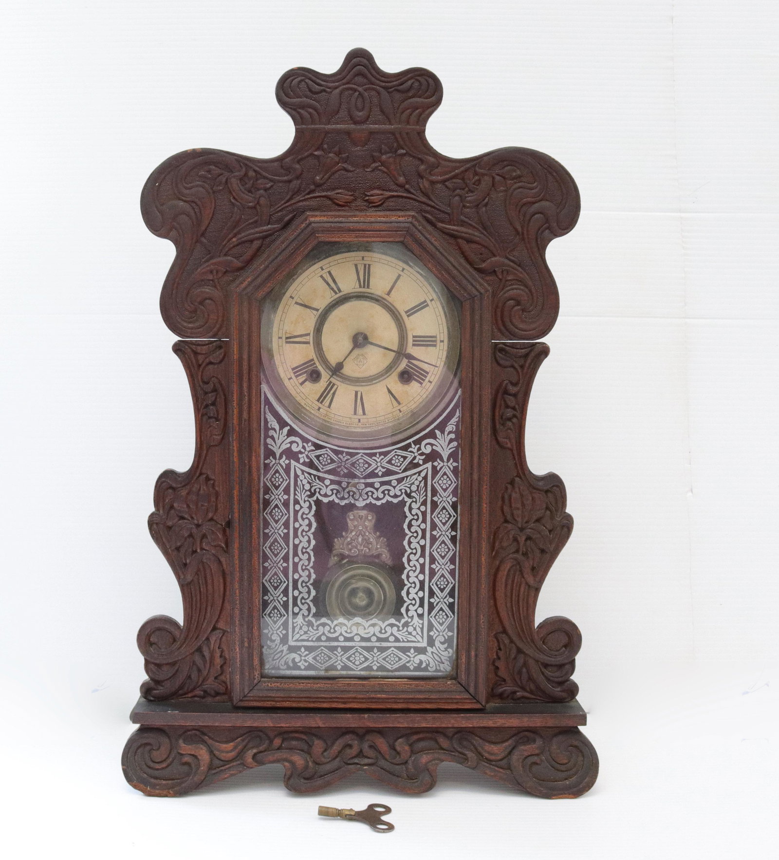 Ansonia mantle clock: Description: Oak and mahogany cased clock - 8 day key wind - etched glass - paper dial Condtion: Working - wear consistent with age and use Size: 22" X 14" Consignor: JS Terms: This is an On-Site