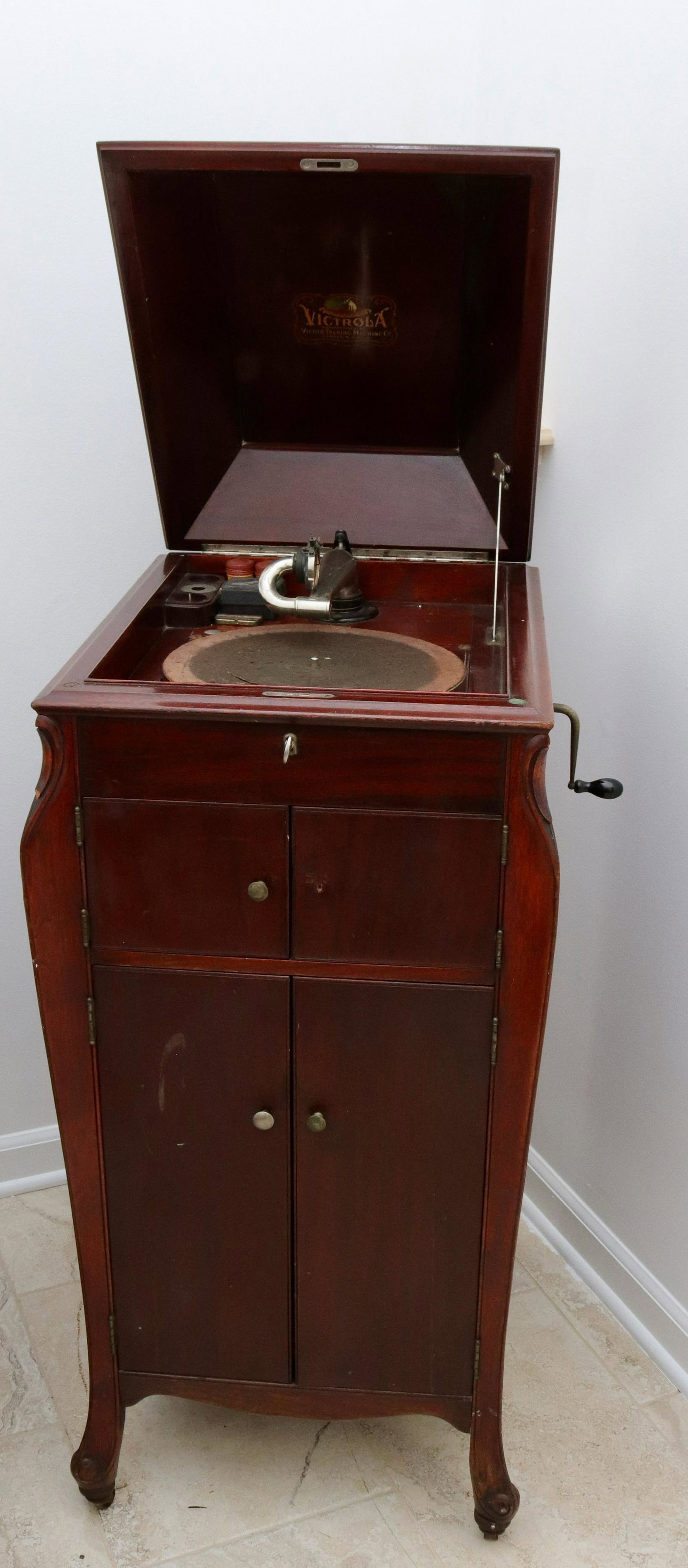 Victrola talking machine: Description: Vintage victor talking machine in mahogany case with records - with crank Condtion: In working order - missing front knob Size: 43" X 19" X 22 1/2" Consignor: JS Terms: This is an On-