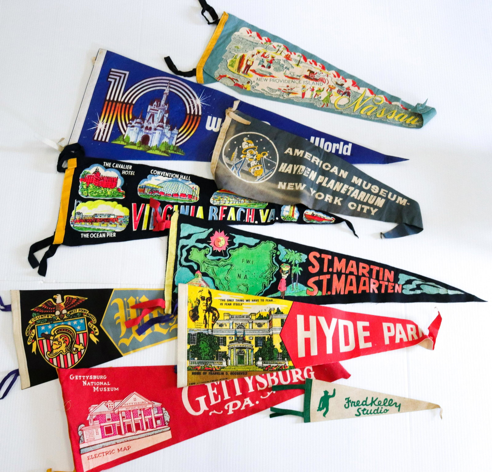 Vintage pennant lot: Description: (9) including - west point, virginia beach, fred kelly studio, gettysburg, and walt disney world Condtion: Wear consistent with age and use Size: 11" TO 28" L Consignor: JS Terms: This
