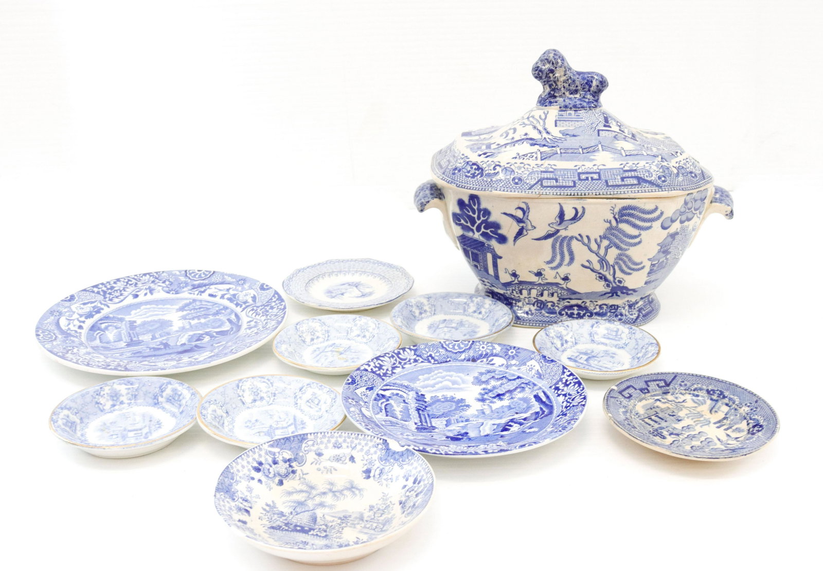 Group lot of blue and white transferware: Description: Including - tureen with lid, side plate, saucer, and (8) butters pats Condtion: Repair to tureen lid, chip on butter pat, others have minor wear Size: TUREEN 7 1/2" X 8 3/4" Consignor: JS