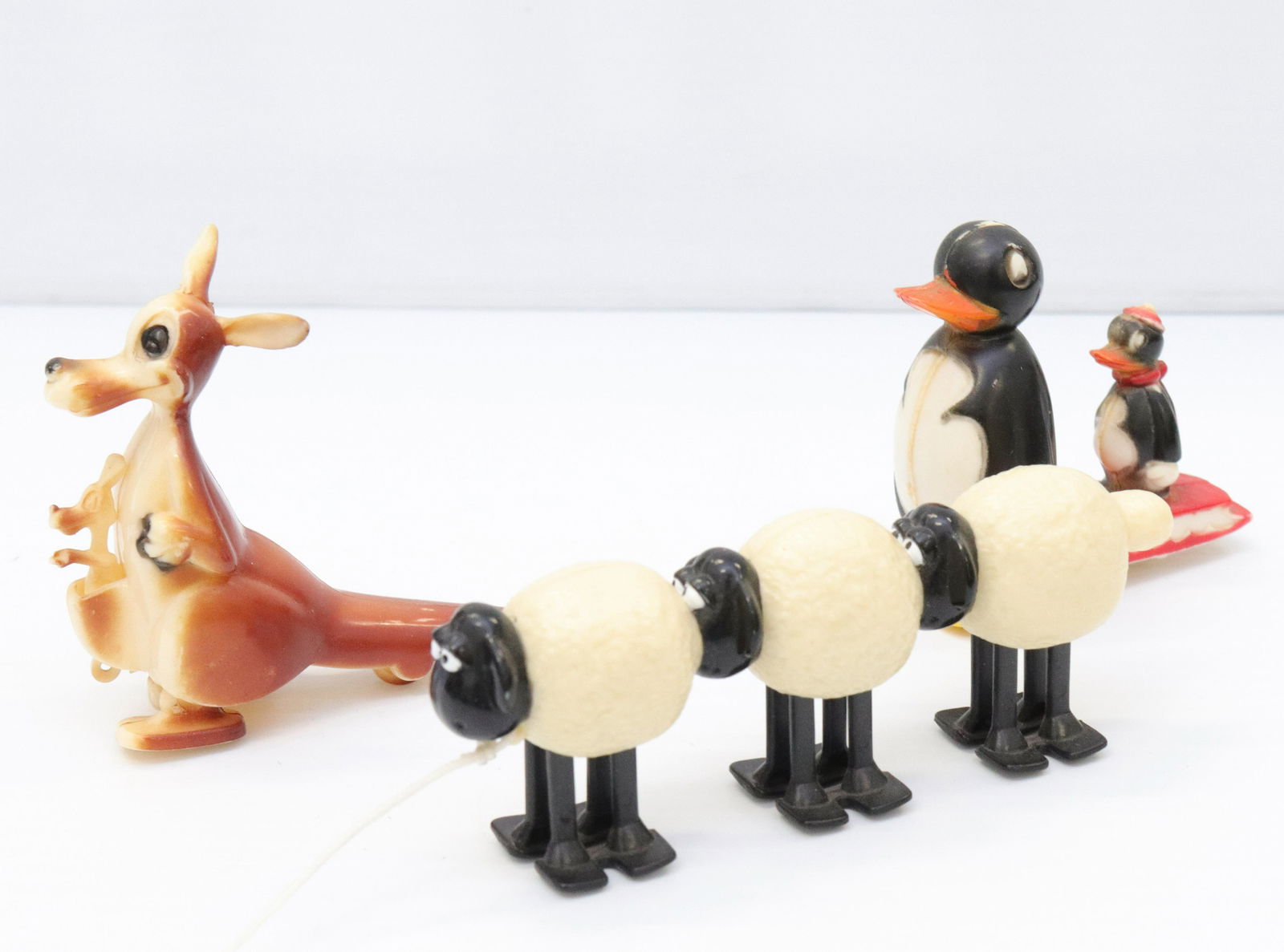 Vintage plastic toy lot: Description: (3) including - penguin pulling sled, (3) walking sheep, and kangaroo with baby joey Condtion: Light wear from age and use Size: 1 1/2" TO 3" H Consignor: JS Terms: This is an On-Site