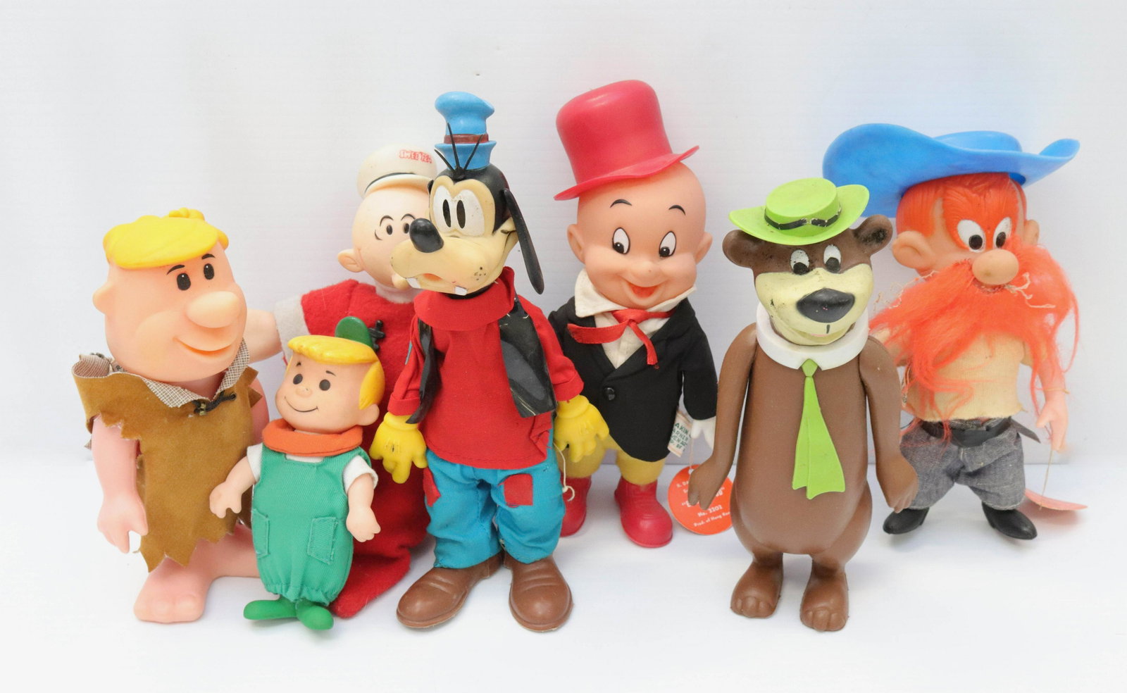 Group lot of cartoon character figures: Description: Including: rubber and cloth. goofy, sweet pea, yogi bear, barney rubble, yosemite sam and elmer fudd Condtion: Wear from age and use Size: 5" TO 8 1/4" Consignor: JS Terms: This is an