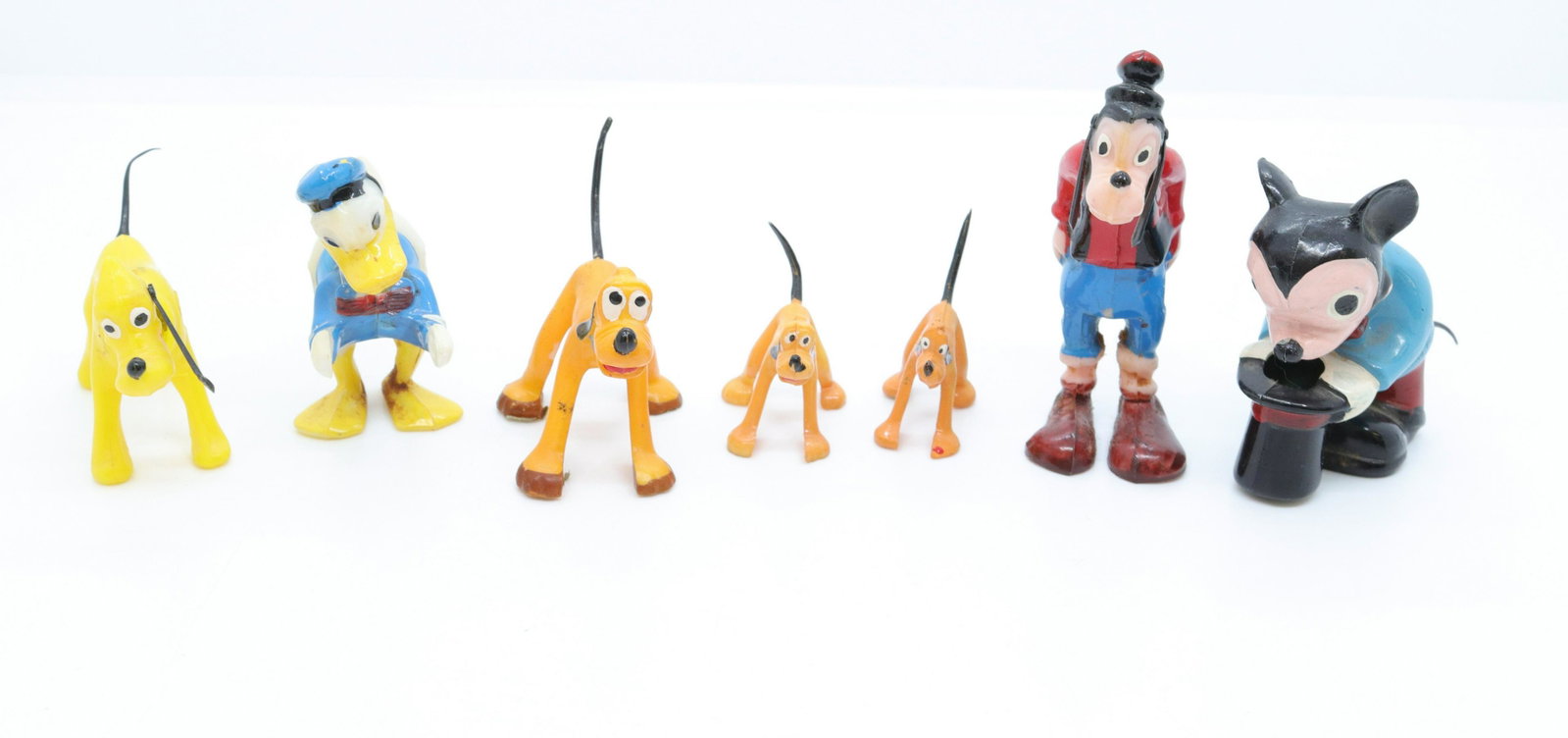 Group lot of plastic disney figures: Description: (4) nodders including - mickey mouse, goofy, donald duck, and pluto by; marx - and (3) pluto figures Condtion: Pluto nodder is missing an ear Size: 2 3/4" H (NODDERS) Consignor: JS Terms: