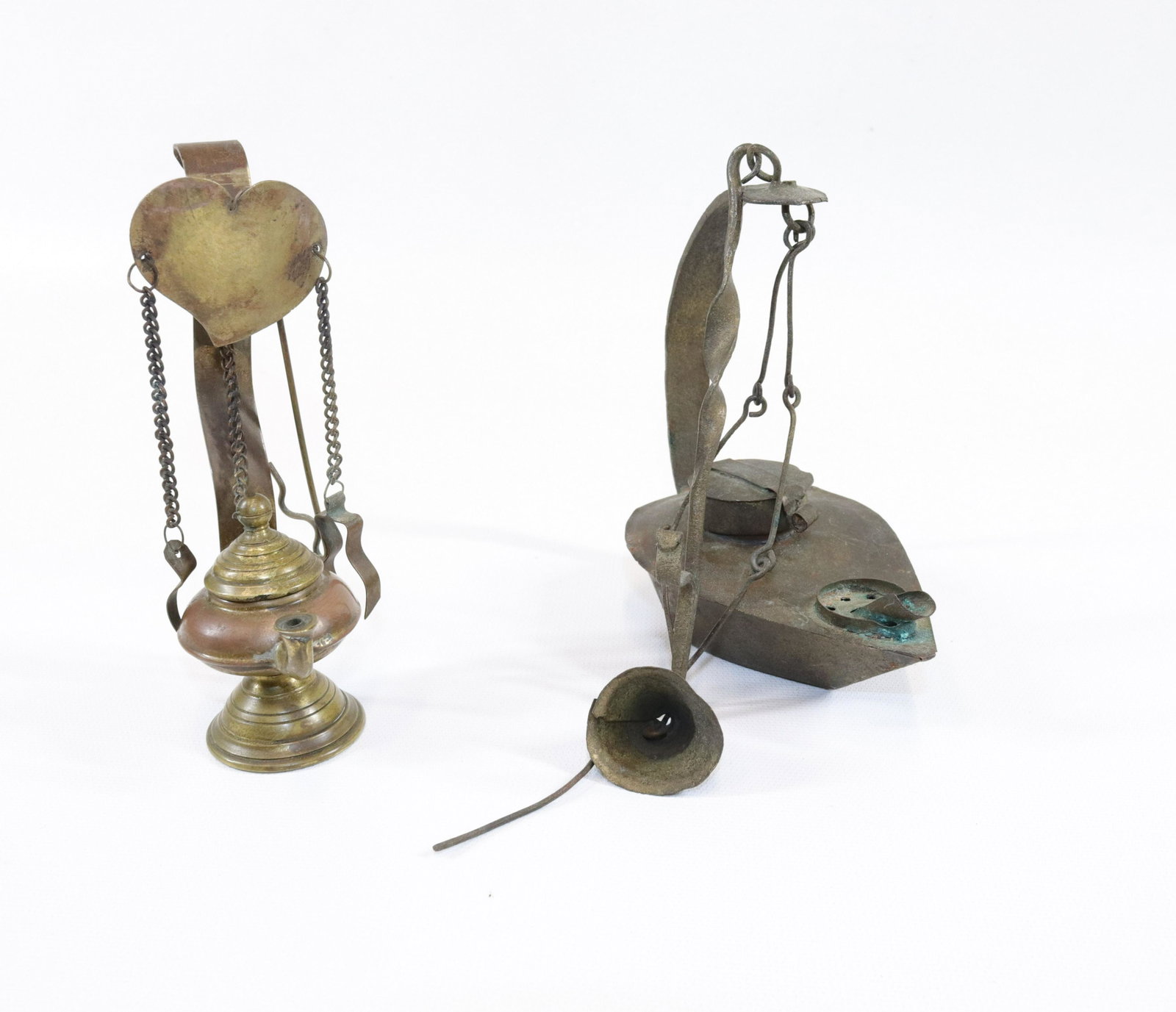 PR. OF EARLY LIGHTING DEVICES: INCLUDING - BRASS BETTY LAMP WITH PICK AND SNUFFER - TURNED BRASS LAMP WITH HEART MOTIF SIZE: 4 3/4" X 4 3/4" - 5 1/4" X 1 1/2"