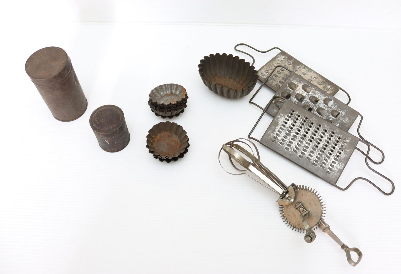 GROUP LOT OF VINTAGE KITCHEN ITEMS: INCLUDING - BAKING MOLDS, TIN CONTAINERS, GRATERS, AND LADD EGG BEATER (1915) SIZE: EGG BEATER 11 3/4" L TERMS: THIS SALE WILL BE ONLINE ONLY. PICK-UP WILL BE ON-SITE AT 14 CHURCH ST. BETHLEHEM, PA 18
