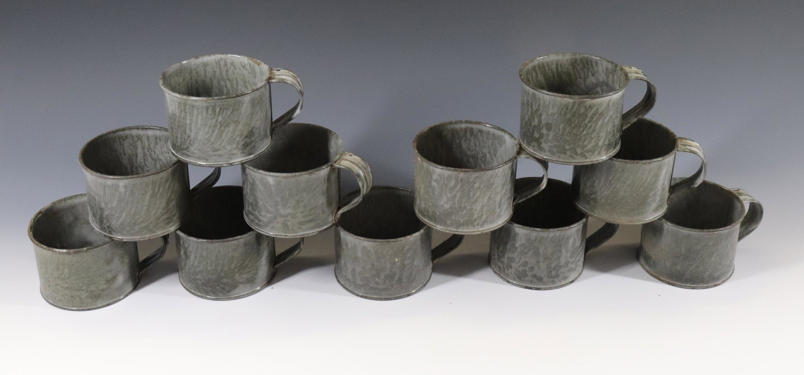 PORCELAIN ENAMEL TIN MUGS: (11) MUGS ALL IN A TWO COLOR GREY - CIRCA 1920'S Dimensions 2 1/2" X 4 3/4" PLEASE READ BEFORE BIDDING – PICKUP FOR THIS AUCTION WILL NOT BE UNTIL THE WEEK OF OCTOBER 25TH. PICK-UP WILL BE FROM 