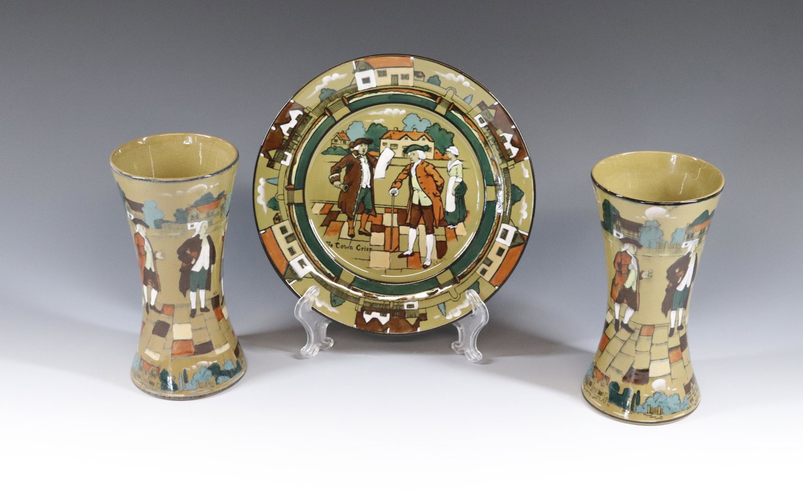 DELDARE BUFFALO POTTERY LOT: YE TOWN CRIER PLATE AND (2) VASES Dimensions 8 1/2" D - 7" X 3 1/2" PLEASE READ BEFORE BIDDING – PICKUP FOR THIS AUCTION WILL NOT BE UNTIL THE WEEK OF OCTOBER 25TH. PICK-UP WILL BE FROM 9:00AM T
