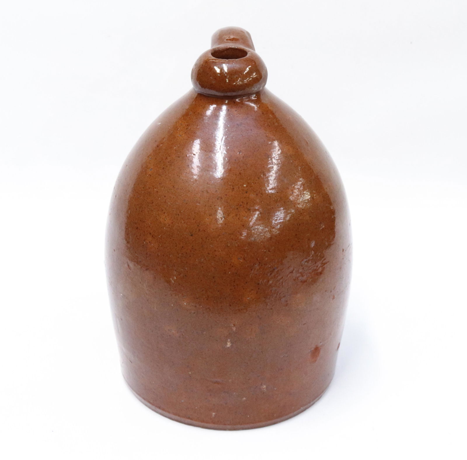 REDWARE STORAGE JUG: ORANGE BODY WITH BROWN SPECKLES. APPLIED HANDLE. Dimensions 11 3/4" H PLEASE READ BEFORE BIDDING – PICKUP FOR THIS AUCTION WILL NOT BE UNTIL THE WEEK OF OCTOBER 25TH. PICK-UP WILL BE FROM 9:00AM