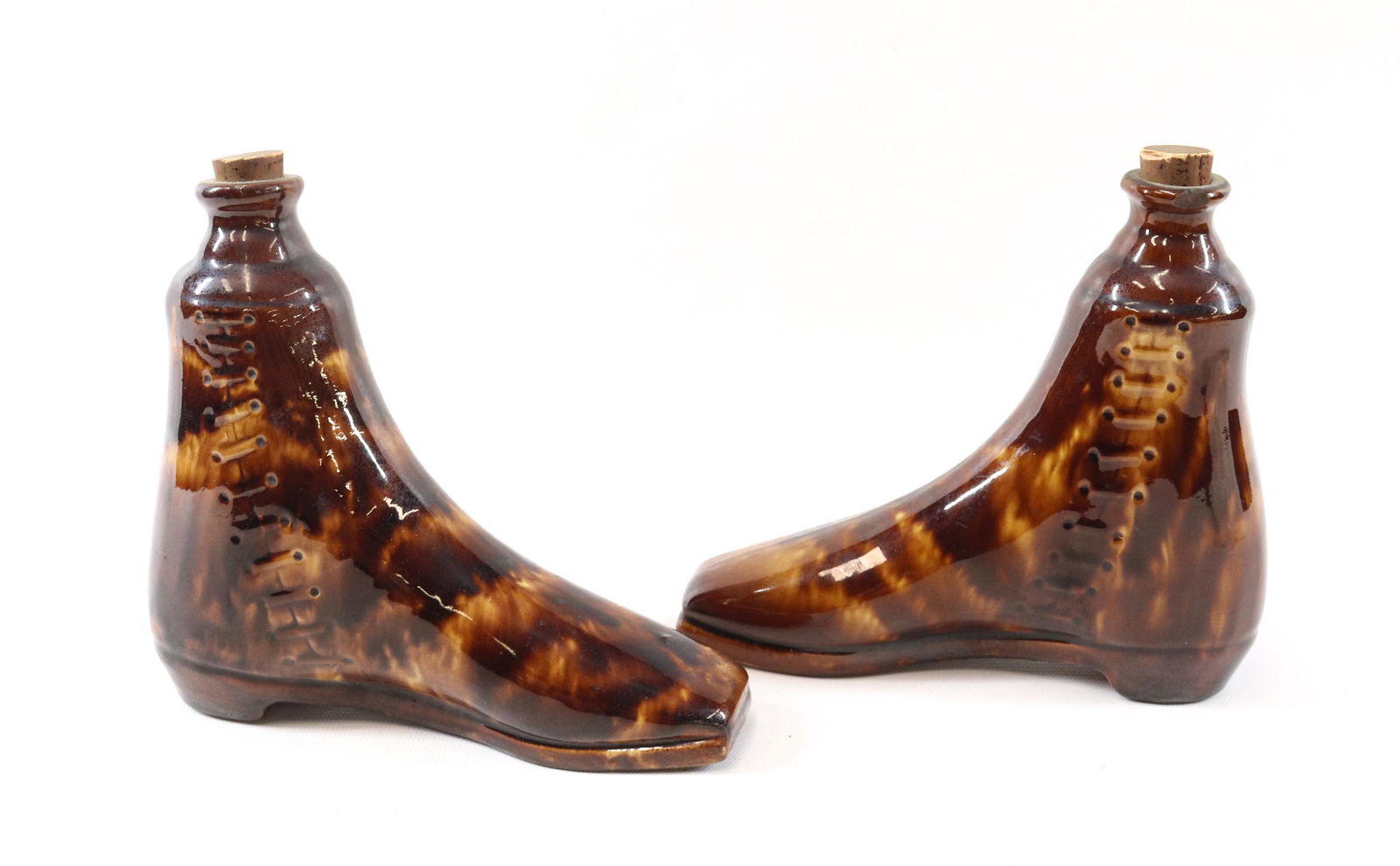 PAIR OF ROCKINGHAM BOOT FLASKS: LACED UP BOOTS WITH CORK STOPPERS Dimensions 6" X 7" PLEASE READ BEFORE BIDDING – PICKUP FOR THIS AUCTION WILL NOT BE UNTIL THE WEEK OF OCTOBER 25TH. PICK-UP WILL BE FROM 9:00AM TILL 4:00PM R