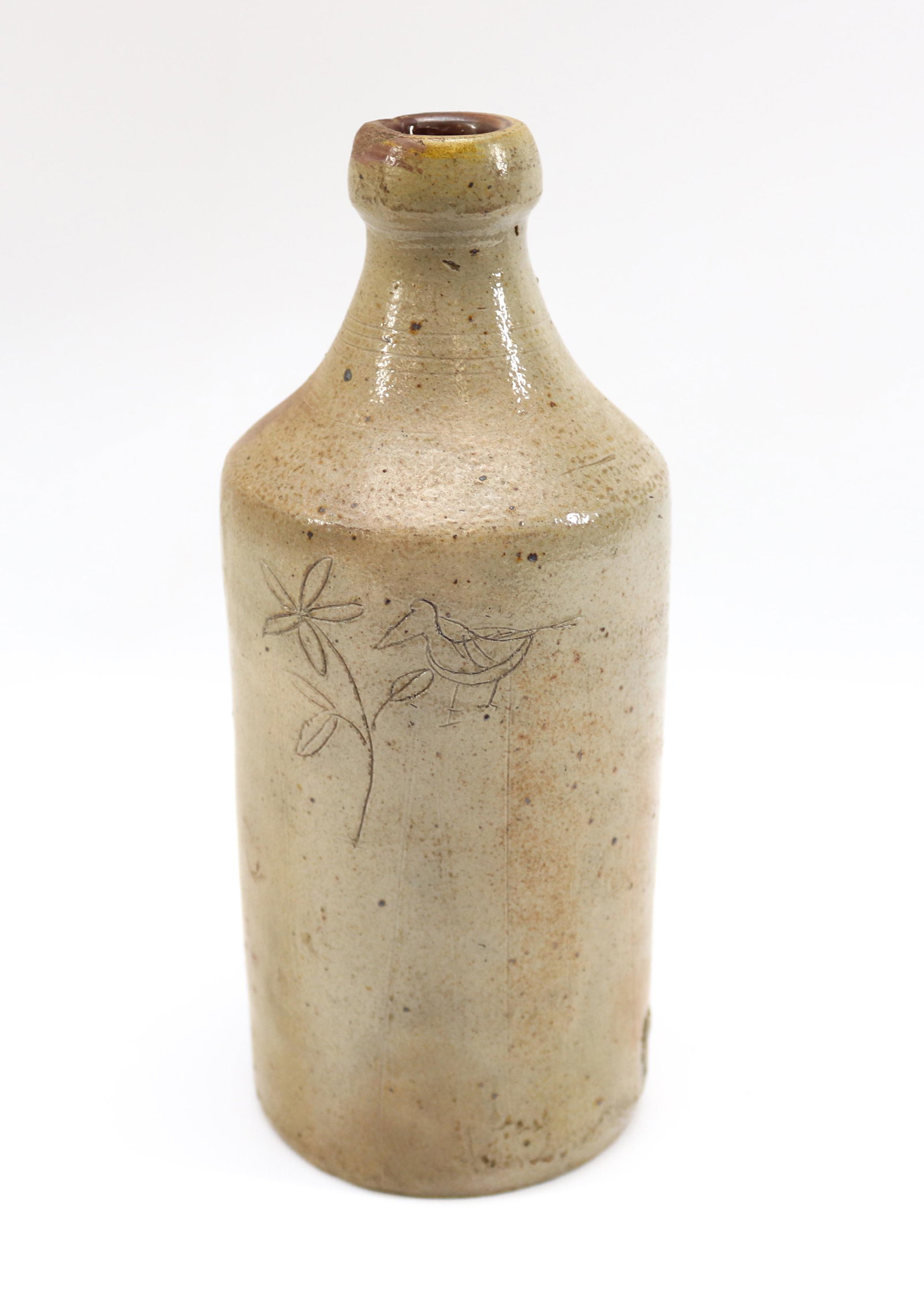 STONEWARE BOTTLE WITH INCISED DECORATION: HAND DONE FLOWER AND BIRD Dimensions 9 1/4" H PLEASE READ BEFORE BIDDING – PICKUP FOR THIS AUCTION WILL NOT BE UNTIL THE WEEK OF OCTOBER 25TH. PICK-UP WILL BE FROM 9:00AM TILL 4:00PM – YOU