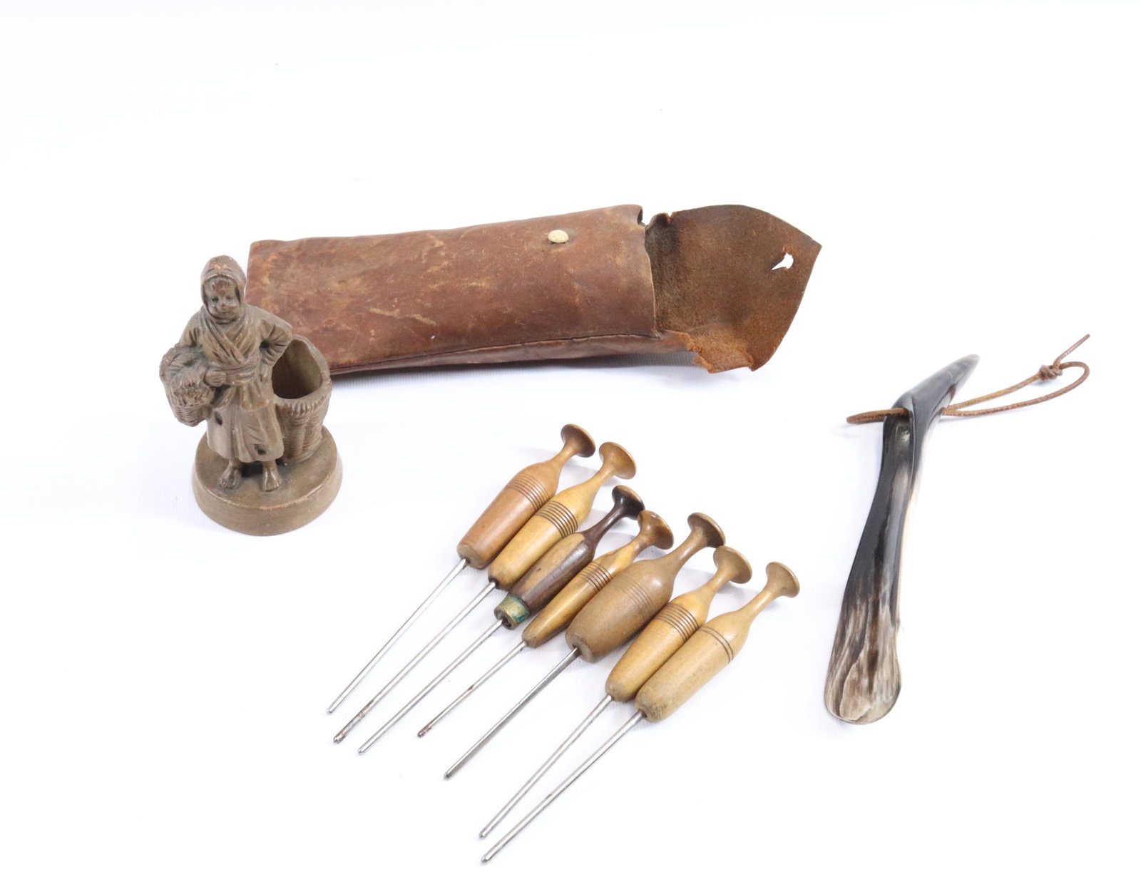 EARLY SEWING IMPLEMENTS IN POUCH, MATCH HOLDER AND SHOE: SEVEN TURN HANDLED IMPLEMENTS IN LEATHER POUCH WITH BONE KNOB, BROWN GLAZED FIGURAL MATCH HOLDER AND SHOE HORN "MADE IN SCOTLAND" Dimensions MATCH HOLDER 4 1/4" H PLEASE READ BEFORE BIDDING – PI