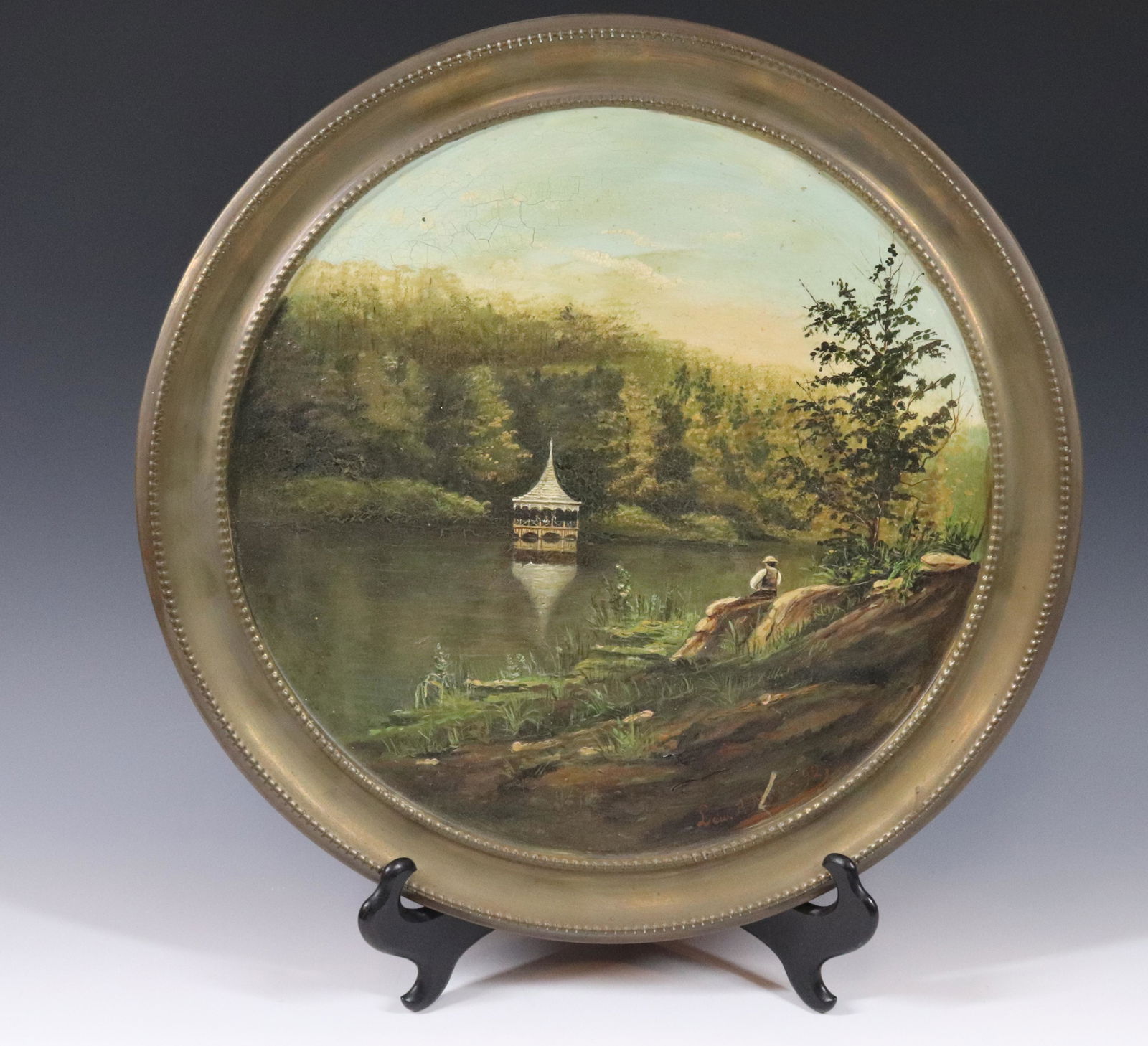 ANTIQUE BRASS PLAQUE WITH PAINTING: BRASS ROUND PLAQUE WITH OIL PAINTING, "GAZEBO ON LAKE" SIGNED; LEW P. MERIAK 1892 SIZE: 15 3/4" DIAMETER PLEASE READ BEFORE BIDDING – PICKUP FOR THIS AUCTION WILL NOT BE UNTIL THE WEEK OF OCTOBER 25