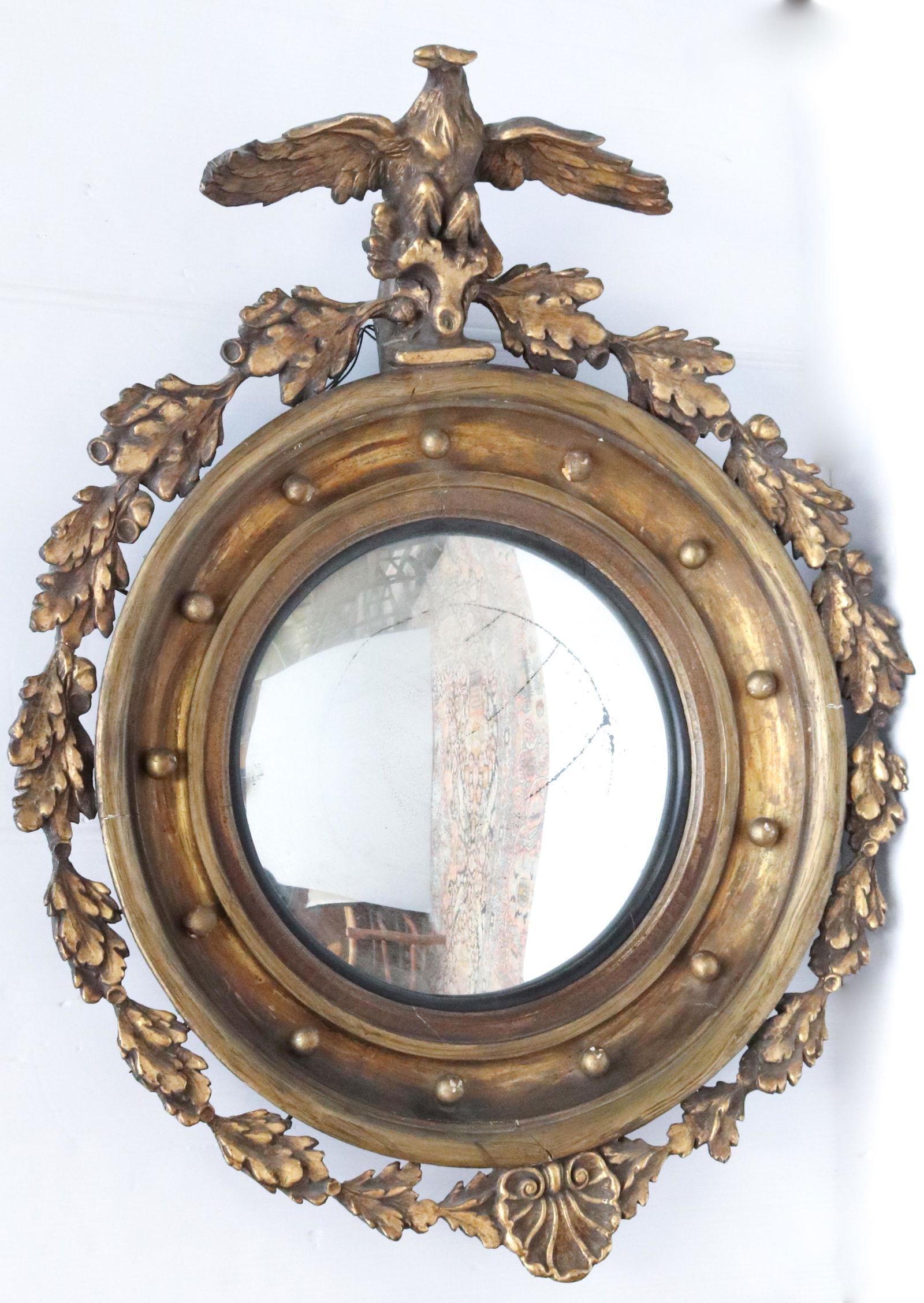 ORNATE GILT CONVEX MIRROR WITH EAGLE: CONVEX MIRROR SURROUNDED BY 13 BALLS. EAGLE PERCHED AT TOP WITH OAK LEAVES AND ACORNS AROUND CIRCUMFERENCE WITH SHELL AT BOTTOM. GILT SURFACE. SIZE: 39" X 31" TOTAL SIZE PLEASE READ BEFORE BIDDING –