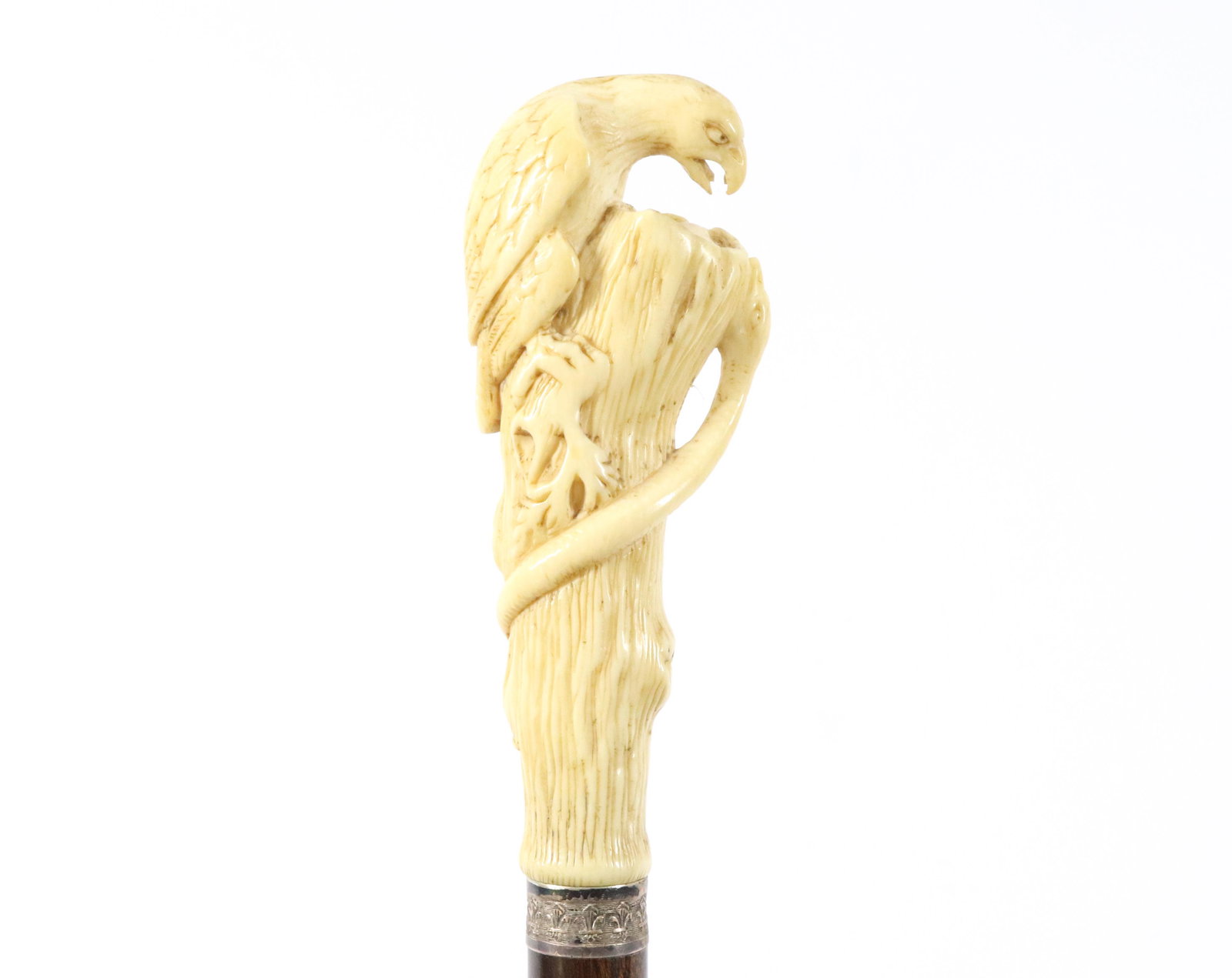 CIVIL WAR ERA CARVED BONE EAGLE CANE: FULL-BODIED EAGLE (THE NORTH) GUARDING ITS NEST OF EGGS (THE UNION OF STATES) FROM THE SNAKE (THE SOUTH). THIS MOTIF SOMETIMES CALLED "DEATH TO TRAITORS". DECORATED SILVER COLLAR ON BIRCH SHAFT. HORN 