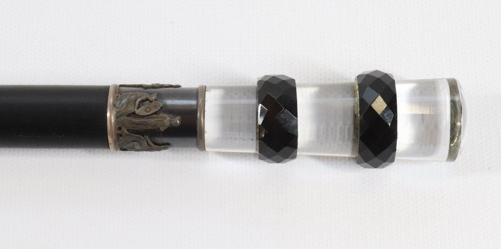 VIENNESE CARVED HARDSTONE DRESS CANE: 19TH C. HARD STONE KNOB CUT FROM CRYSTALLIZED JASPER. BLACK EBONY SHAFT WITH BRONZE FERRULE. CLASSICAL FIGURES DECORATE SILVER BAND SIZE: OVERALL LENGTH 38 1/2" PLEASE READ BEFORE BIDDING – PICKUP F