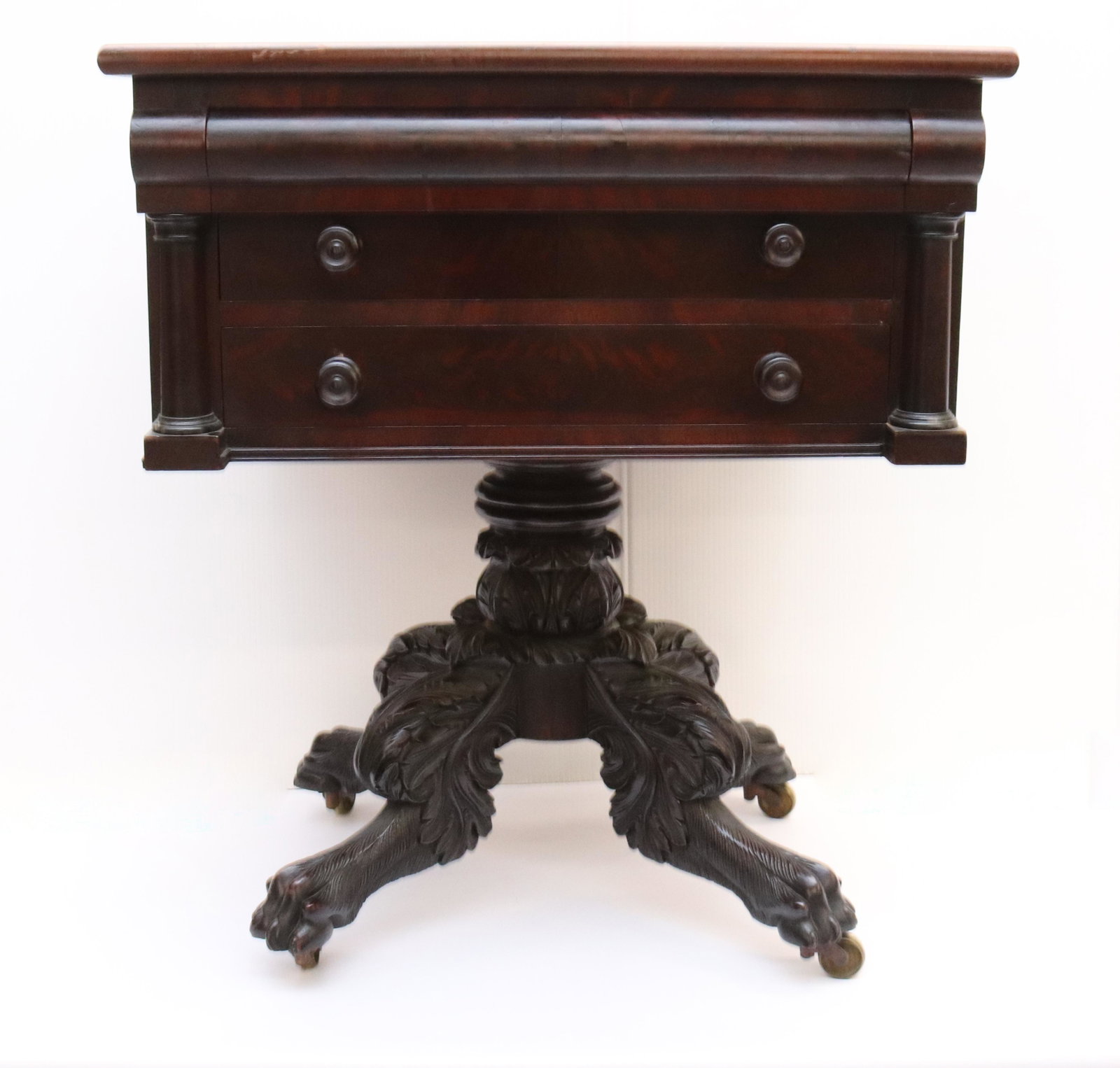 19TH C. MAHOGANY WORK TABLE WITH WRITING SURFACE: PULL-OUT WRITING SURFACE WITH COMPARTMENTS OVER TWO DRAWERS. CARVED PAW FOOT BASE ON BRASS CASTERS SIZE: 28 1/2" X 24" X 21" PLEASE READ BEFORE BIDDING – PICKUP FOR THIS AUCTION WILL NOT BE UNTIL TH