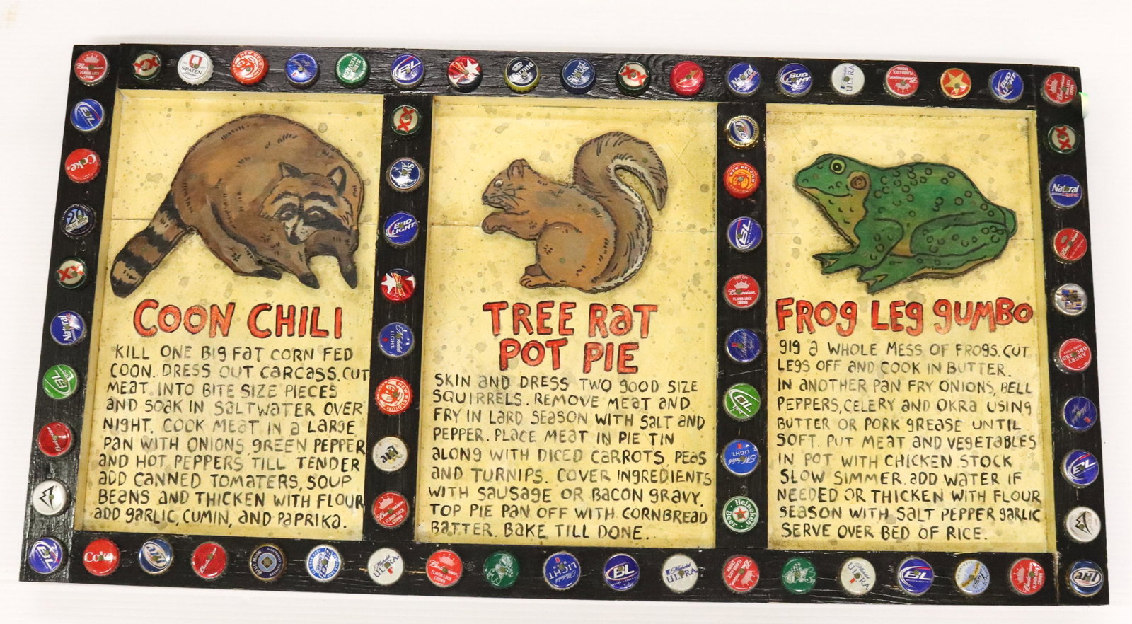 OUTSIDER ART PAINTED RECIPE BOARD: THREE PANELS WITH CUT OUT ANIMALS AND PAINTED RECIPES. TRIMMED IN BEER BOTTLE CAPS. SGND. BOTTOM RIGHT SIZE: 17" X 32" PLEASE READ BEFORE BIDDING – PICKUP FOR THIS AUCTION WILL NOT BE UNTIL THE WEEK