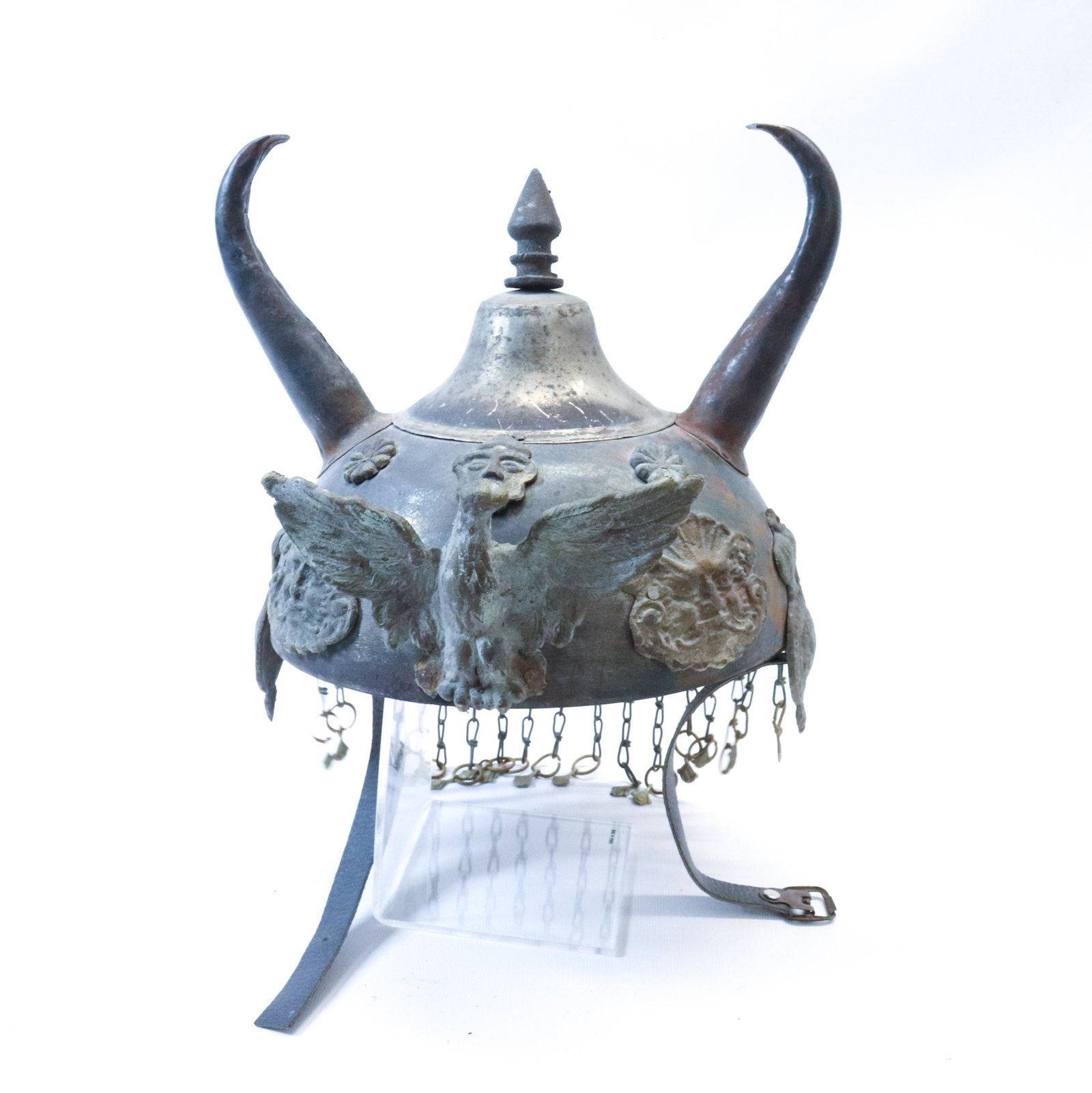 TIN MILITARY HELMET: HELMET WITH EAGLE AND HORNS - WITH METAL FACES AND SYMBOLS - METAL TASSLES HANG FROM BACK OF HELMET -8" INSIDE DIAMTER