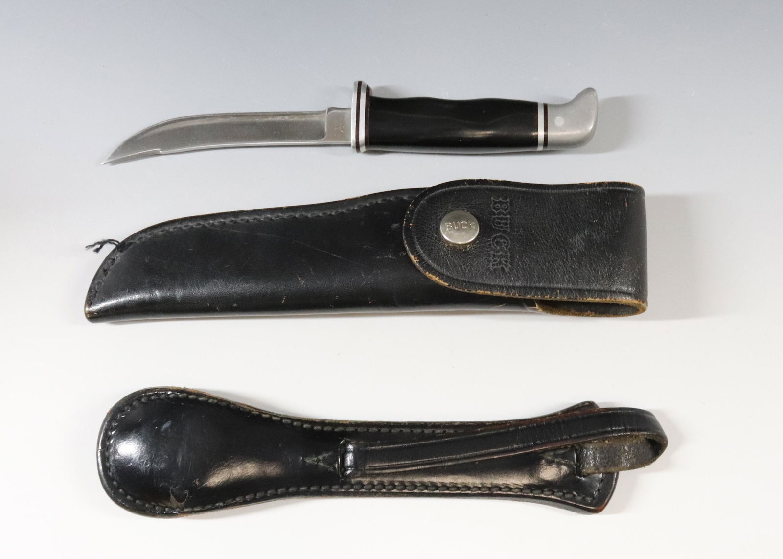 BUCK KNIFE AND BUCHEIMER JUNIOR BLACKJACK: KNIFE WITH LEATHER SHEATH MRKD. BUCK Dimensions: BLADE 4 1/4"...TOTAL LENGTH 8 3/8" Terms: Hartzell's Auction Gallery will handle most of the shipping in-house. WE do reserve the right to not ship som
