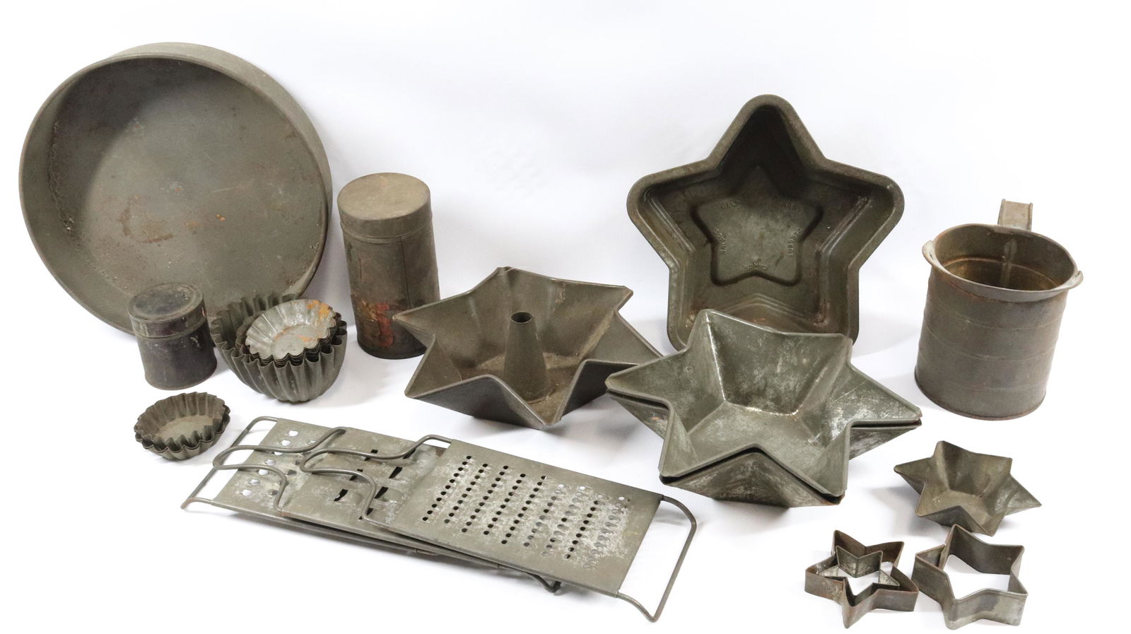 GROUP LOT OF TIN KITCHENWARE: INCLUDING: GRATERS, MOLDS, MEASURES AND MORE Dimensions: LARGEST STAR 9" Terms: Hartzell's Auction Gallery will handle most of the shipping in-house. WE do reserve the right to not ship some large ite